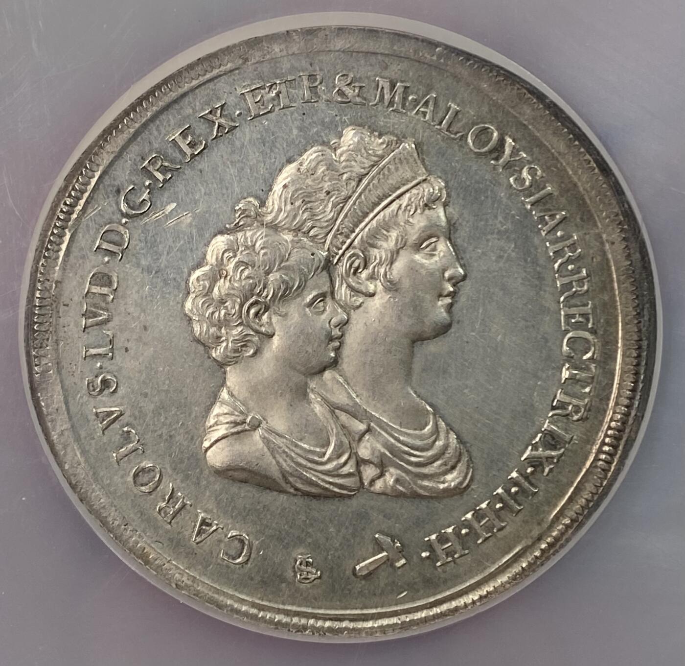 万国钱币拍卖第063期 NGC MS63 意大利托斯卡纳大公国1803年超大型10里拉大银币 正面为年幼的卡洛·路德维科和母亲摄政女王玛丽亚·路易萨，背面是含有法国波旁家族，拿破仑家族和美第奇家族等构成的华丽盾徽。此品种发行的首年，发行量9027枚且无后铸。此枚独特的地方在于币边比常见的更厚，尺寸较常规的更大，应是打制在了另外的币坯上，有试铸币的可能性。