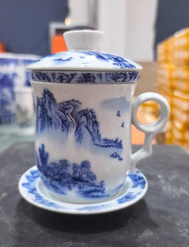 景德镇青花山水陶瓷茶杯套装，全新未使用，带盖带托盘，茶水分离设计，泡茶方便。杯身手绘山水图案，意境优美，陶瓷材质，做工细致，容量约350ml