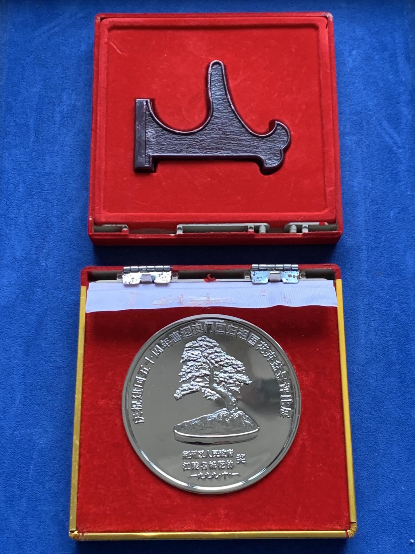 《竞宝斋》第474场 周日，周一 2场连拍 （全场包邮）欢迎送拍 1999年庆祝澳门回国荆州花卉盆景展纪念奖章，铜章电镀，220.7克，直径79.2mm，面积大，沉手，设计制作精美，保存较好，有原盒，盒子有破损，少见。