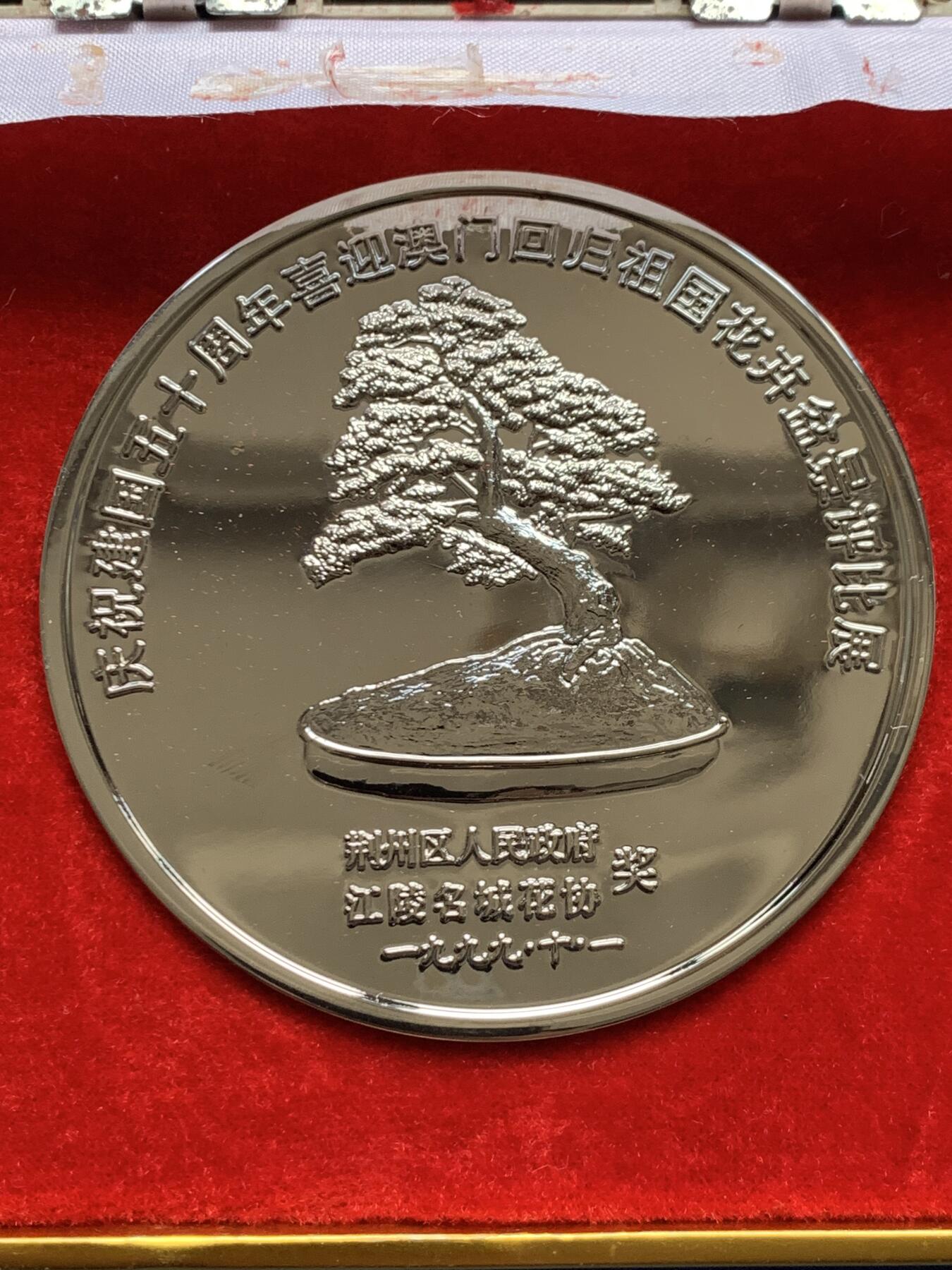 《竞宝斋》第474场 周日，周一 2场连拍 （全场包邮）欢迎送拍 1999年庆祝澳门回国荆州花卉盆景展纪念奖章，铜章电镀，220.7克，直径79.2mm，面积大，沉手，设计制作精美，保存较好，有原盒，盒子有破损，少见。