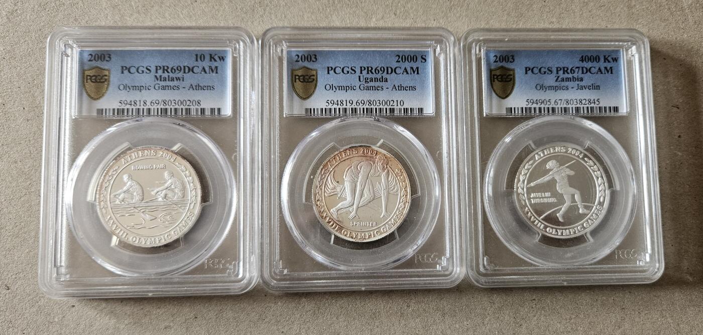 【币将精彩】世界钱币拍卖（2026-4-1） 多国联合发行2004年雅典奥运纪念银币一组PCGS 有氧化 全套三枚，赞比亚，马拉维和乌干达联合发行，每枚20克，发行量500套。