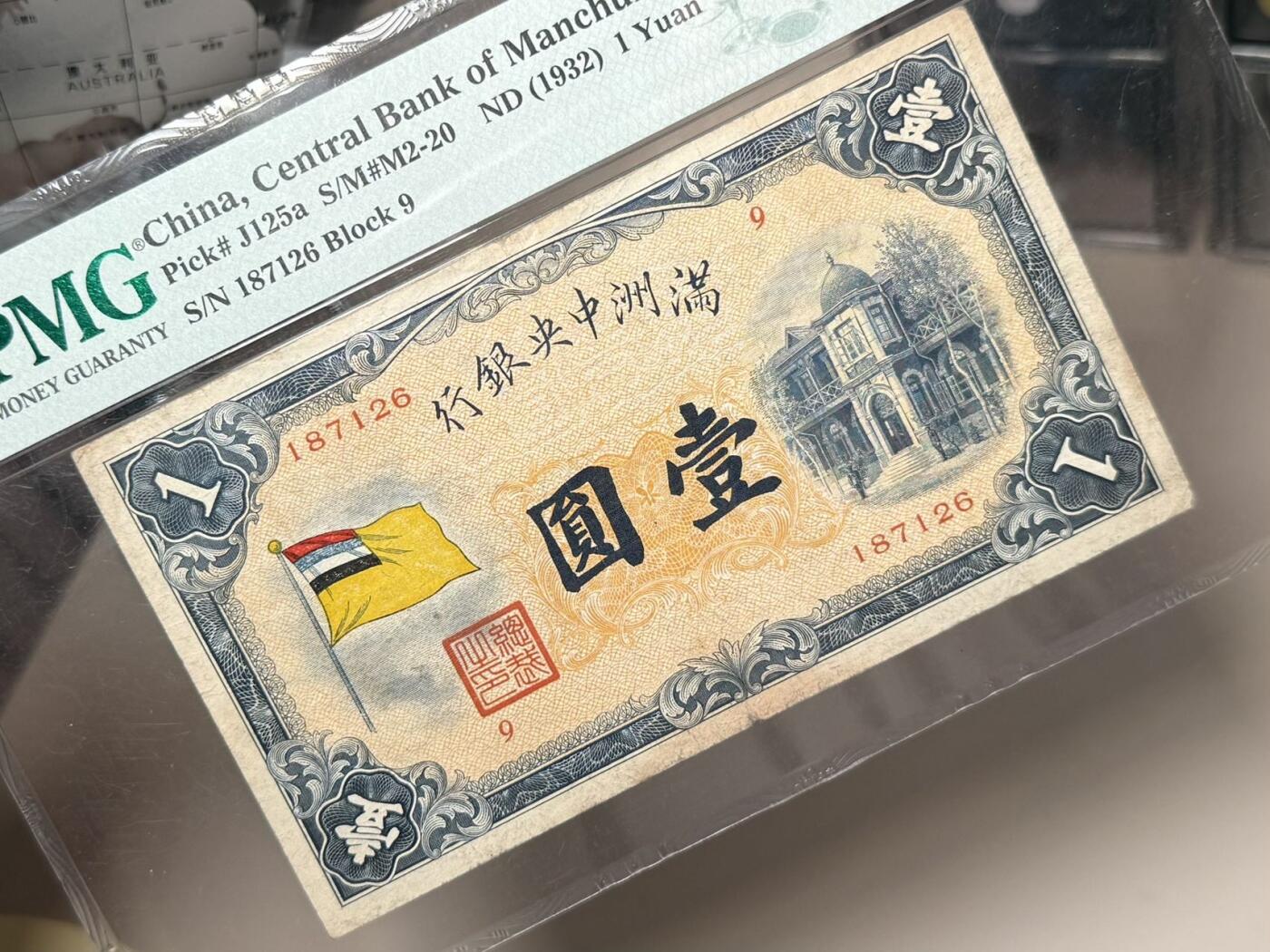 【乾奕收藏】出民国21年1932年满洲中央银行五色旗，早期甲号券版本，左侧红蓝白黑满地黄五色旗，右侧伪满皇宫勤民楼图案，美国PMG25分，民国纸币经过80年能保存如此品相实属难得，喜欢的老板不要错过，评级币一切以分数为准，售出非假不退