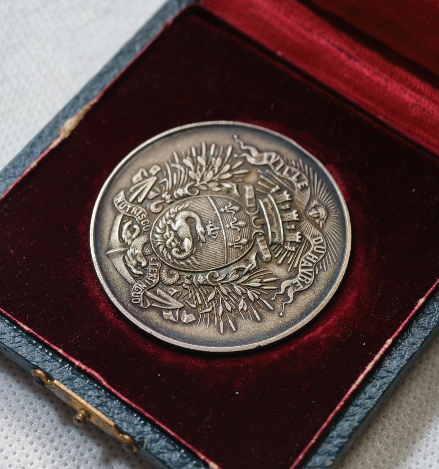 甄臻铺-世界币章拍卖（第56期），送拍享返佣金等优惠多多 法国勒阿弗尔市徽银章，直径40.7毫米，重38.1克，含银量950‰，带原装盒子。正面是勒阿弗尔市徽，火盆上的蝾螈，下方船锚麦穗，边缘月桂枝叶，边缘有个老磕。