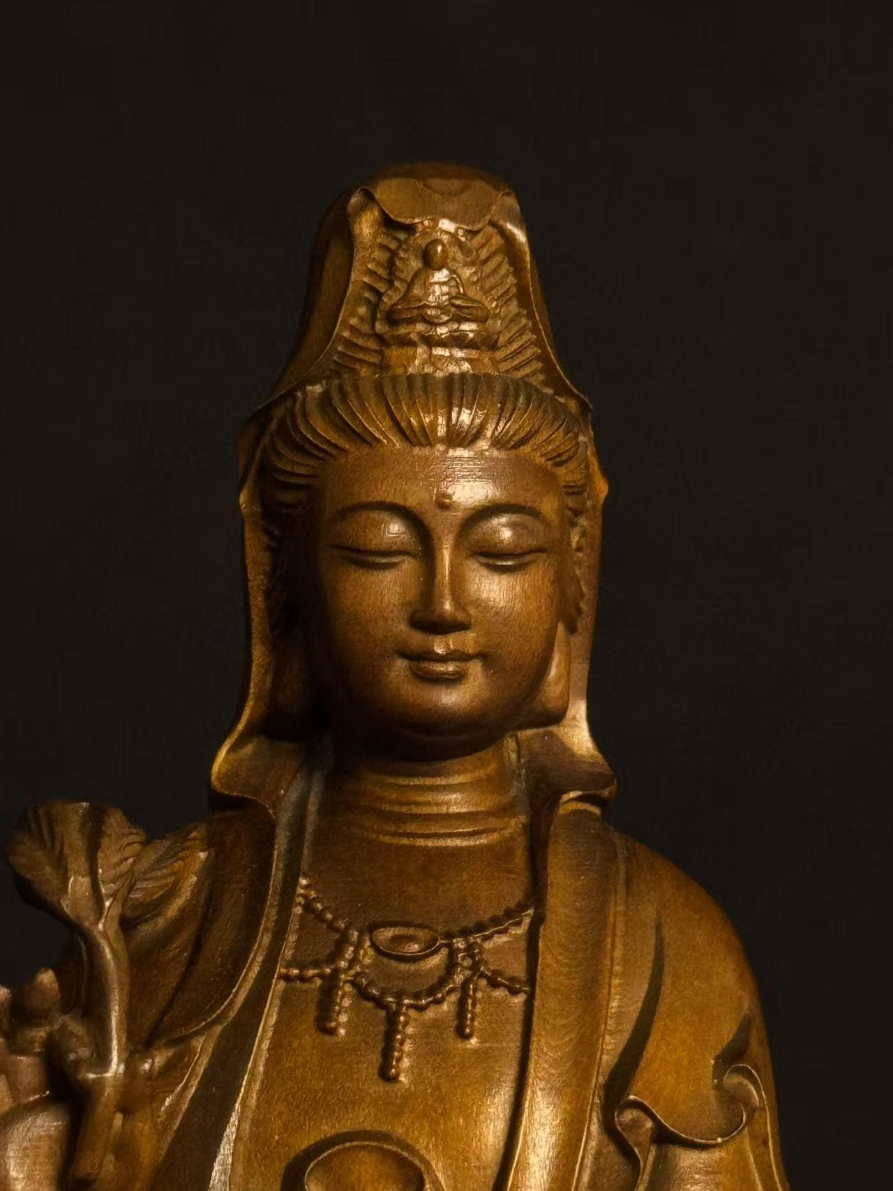 零元拍：黄杨木精雕（古法做旧工艺）观音立像，高约22CM，开脸慈悲宁静，双目微垂，发髻高挽，衣袂飘逸流畅，右手持杨柳枝，左手托净瓶，姿态温婉慈悲，是典型的“杨柳观音”形象。