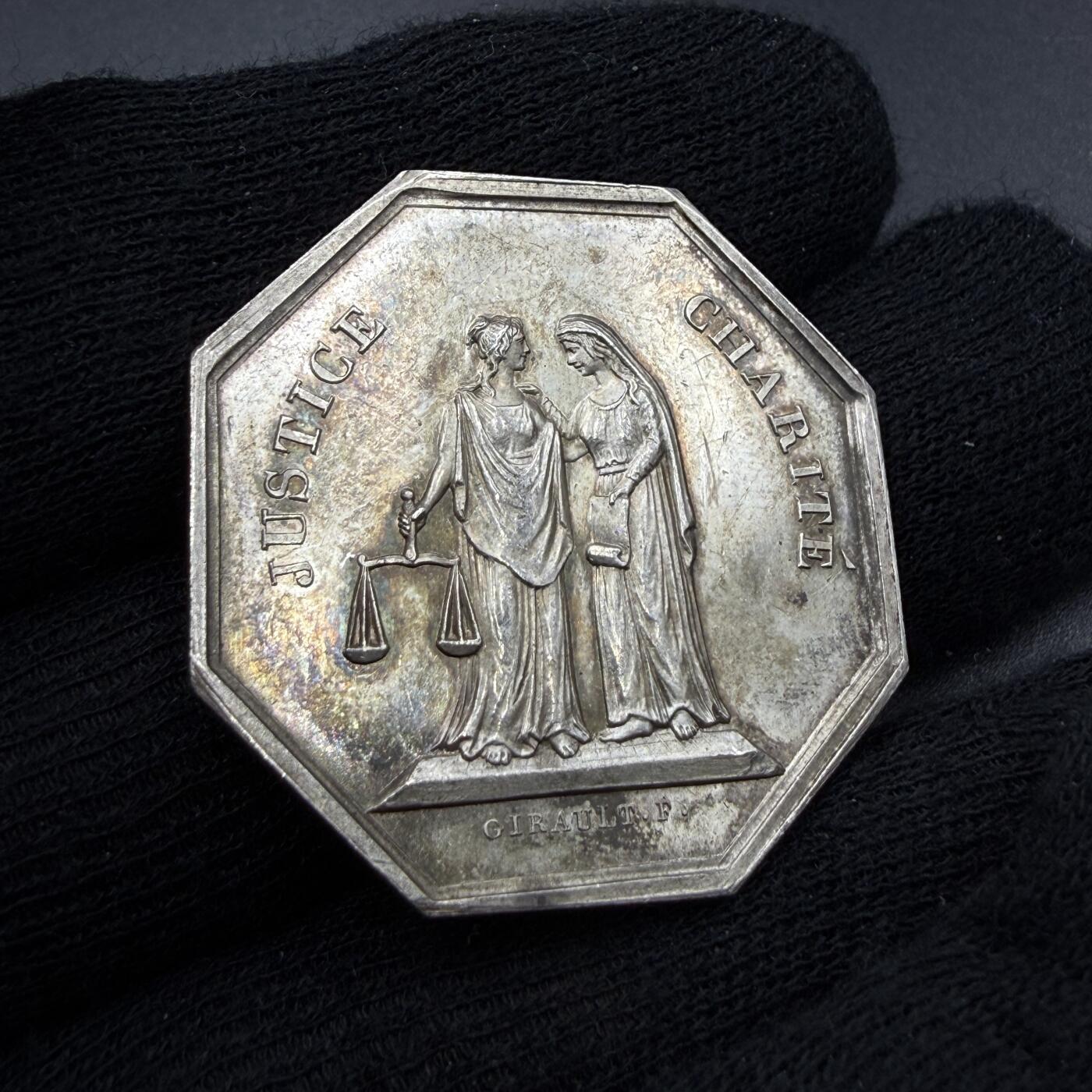 「木头集藏」“春启藏心”——章牌精品专场 Girault.F.～1843年法国马赛代诉人公会八角银章，直径：33.8 mm，12.5 g，边铭：船首 ARGENT （1842-1845年），正面刻画两位女神并肩而立，左侧为正义（JUSTICE），手持天平，代表法律的公平与公正；右侧为慈善（CHARITÉ），手持卷轴，象征司法中的人道与悲悯。二者相互依偎，体现了法国司法理念中“正义与慈悲并存”的核心精神。少见八角，初期版本，品相不错。
