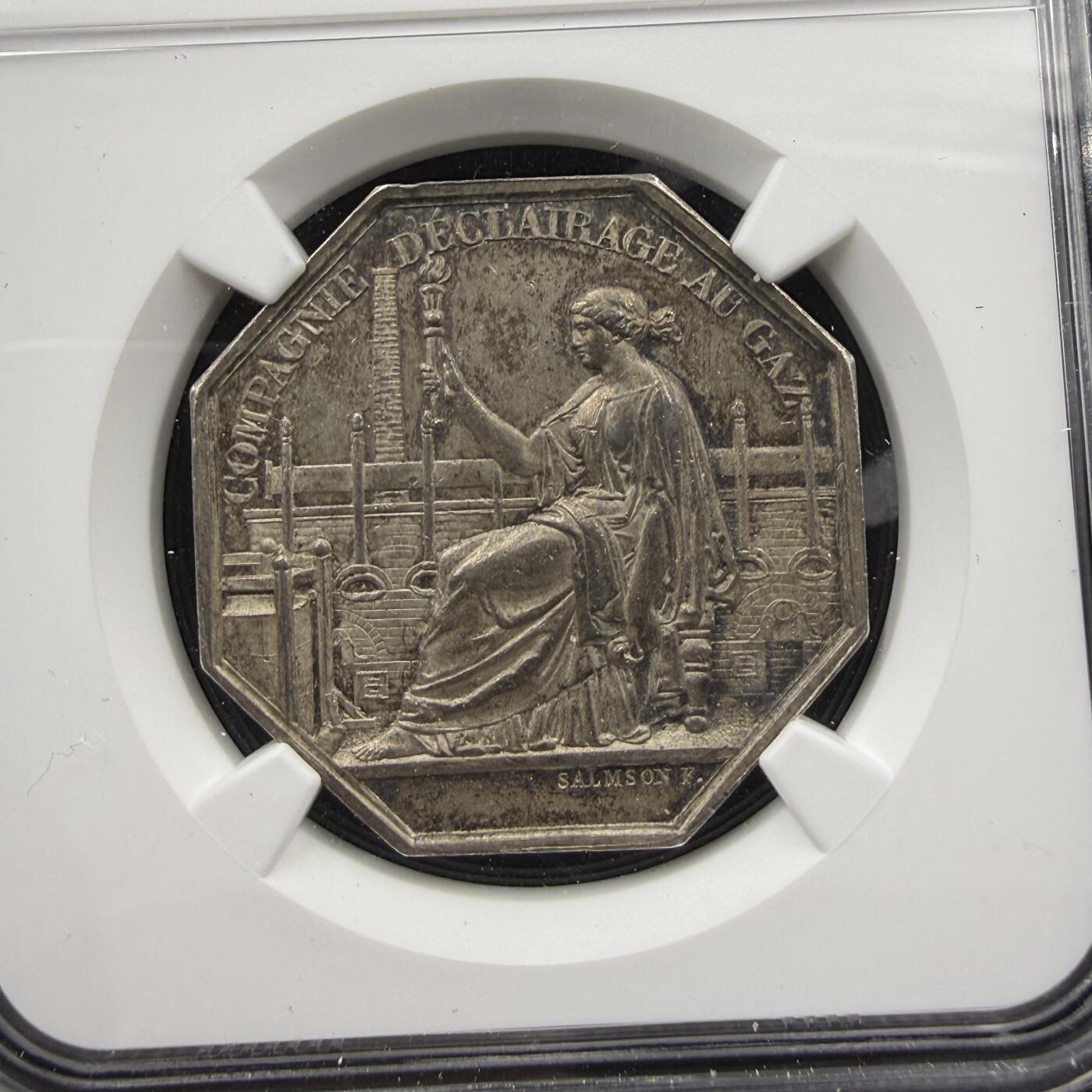 「木头集藏」“春启藏心”——章牌精品专场 1849年法国巴约讷煤气照明公司八角银章，MS 62 ，直径：32 mm，正面女神手持火炬，背景是煤气厂的工业设施管道、烟囱，象征煤气照明为城市带来光明与文明。背面刻画巴约讷市城市盾徽，上方刻画城冠与橡树，代表守护与力量，非常少见的八角，品相不错。