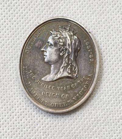 甄臻铺-世界币章拍卖（第56期），送拍享返佣金等优惠多多 - 1887年英国维多利亚女王登基50周年纪念获奖银章，由英国东南铁路公司颁发，椭圆形37.5x31.2毫米，重15克。正面维多利亚女王侧像，背面南东铁路徽章和人物肖像，见图，章顶部有貌似去吊环痕迹或许就是当时铸造时去浇口的痕迹，边缘有一处磕碰，其余完美。适合收藏或研究英国历史、铁路、维多利亚时期相关主题，非常稀少品种