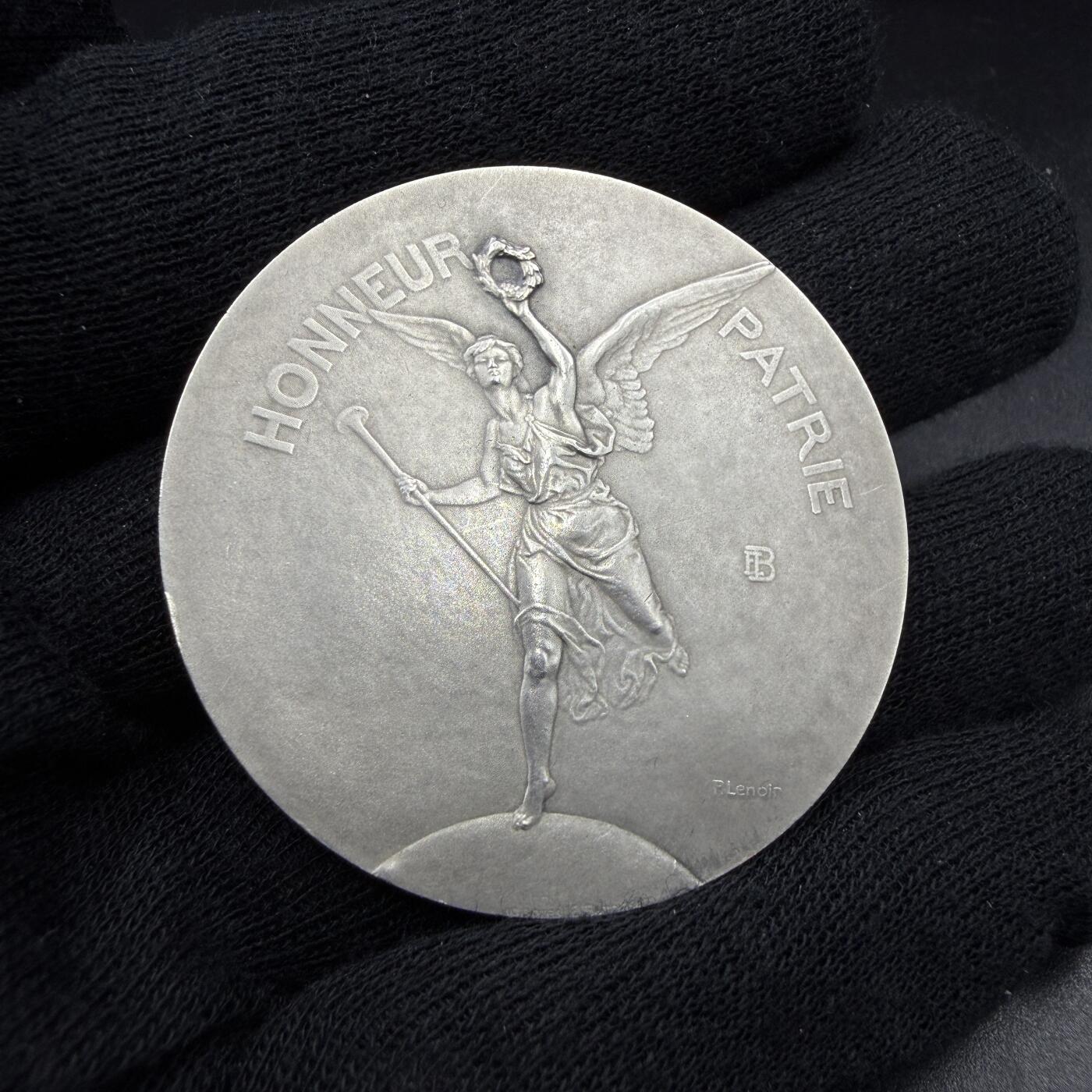 「木头集藏」“春启藏心”——章牌精品专场 P.Lenoir～法国射击协会联盟原盒银奖章，直径：44.5 mm，41.1 g，边铭：菱形厂标 野猪头银标 ARGENT，正面刻画胜利女神手持长号与月桂枝花环，向获奖人飞奔而来。品相不错，原盒正常使用。