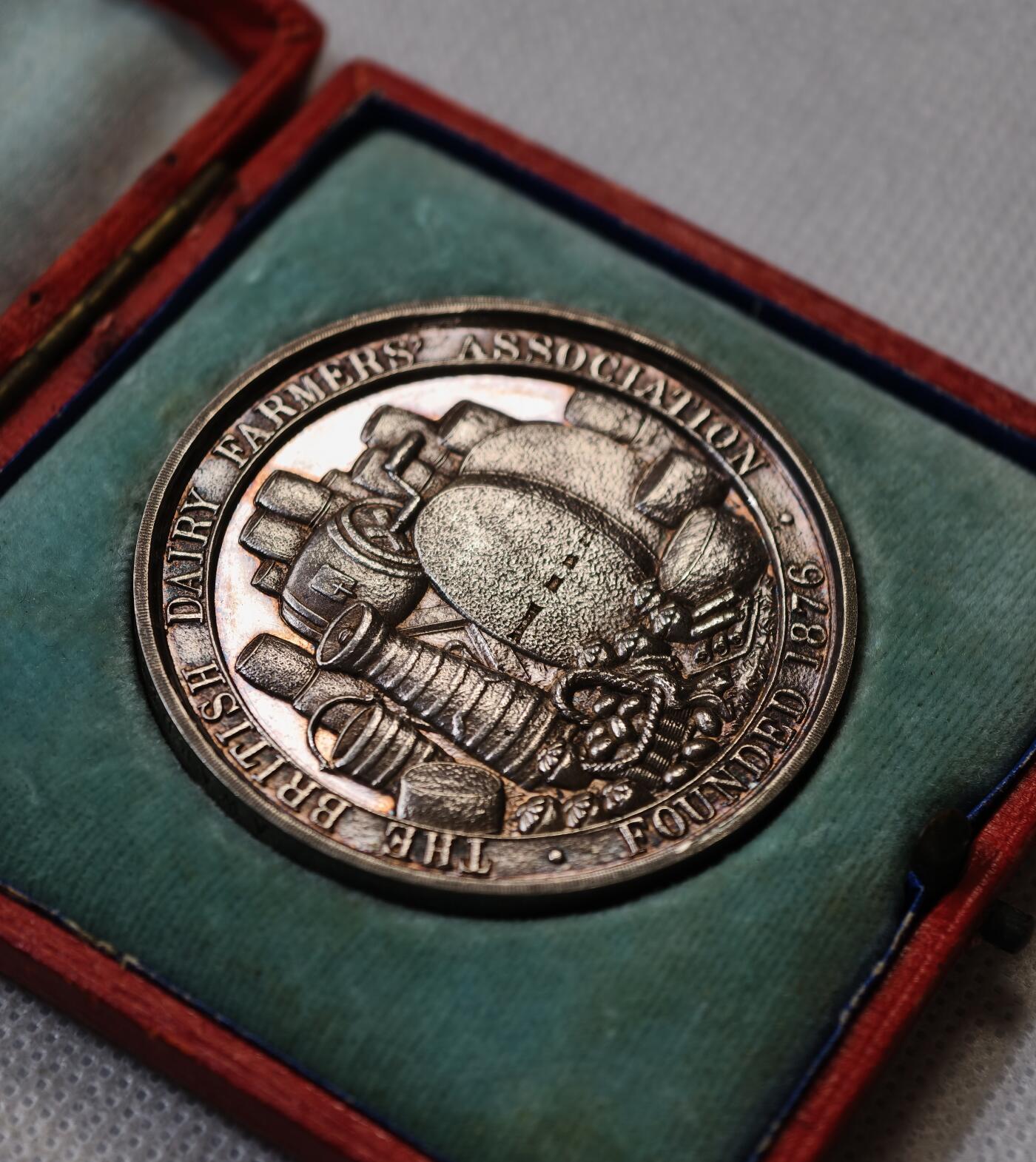 甄臻铺-世界币章拍卖（第56期），送拍享返佣金等优惠多多 1909年英国奶农协会（BRITISH DAIRY FARMERS ASSOCIATION）银质纪念章，直径47.5毫米，重43.722克，带原装红色皮盒。正面是奶牛和小牛图案，背面为奶制品和“FOUNDED 1876”字样，细节清晰，保存完好，包浆自然，带英国官方925银标。