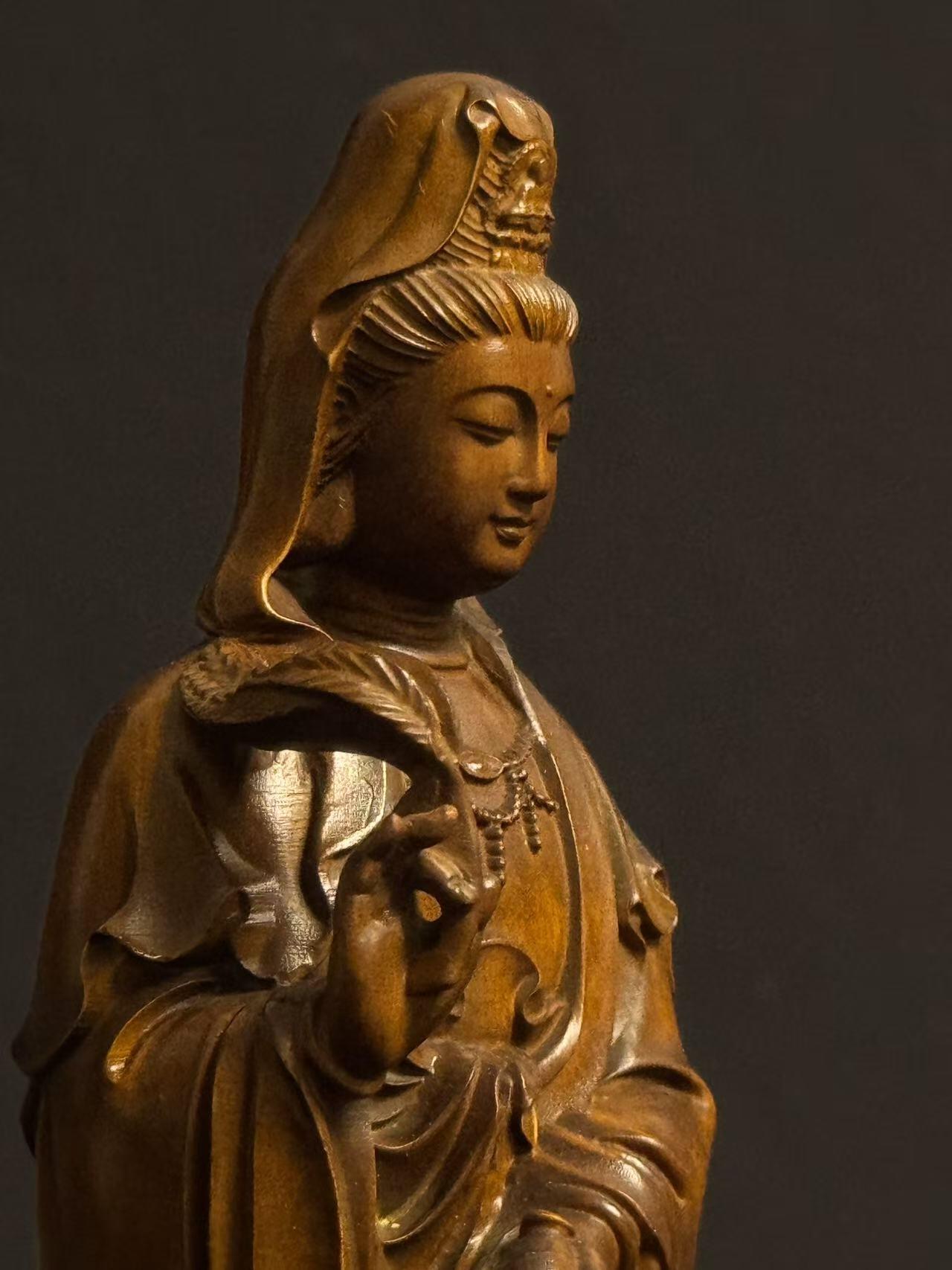 零元拍：黄杨木精雕（古法做旧工艺）观音立像，高约22CM，开脸慈悲宁静，双目微垂，发髻高挽，衣袂飘逸流畅，右手持杨柳枝，左手托净瓶，姿态温婉慈悲，是典型的“杨柳观音”形象。