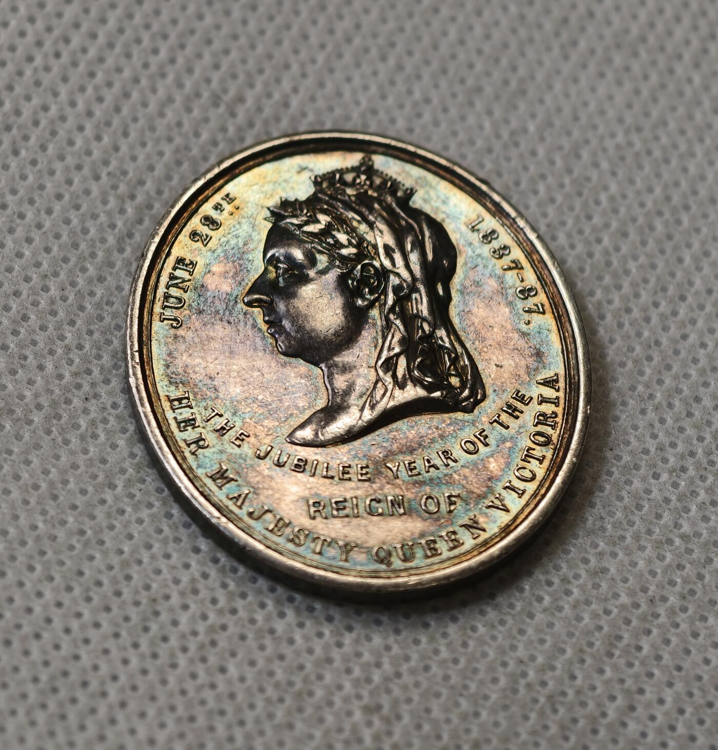 甄臻铺-世界币章拍卖（第56期），送拍享返佣金等优惠多多 1887年英国维多利亚女王登基50周年纪念获奖银章，由英国东南铁路公司颁发，椭圆形37.5x31.2毫米，重15克。正面维多利亚女王侧像，背面南东铁路徽章和人物肖像，见图，章顶部有貌似去吊环痕迹或许就是当时铸造时去浇口的痕迹，边缘有一处磕碰，其余完美。适合收藏或研究英国历史、铁路、维多利亚时期相关主题，非常稀少品种