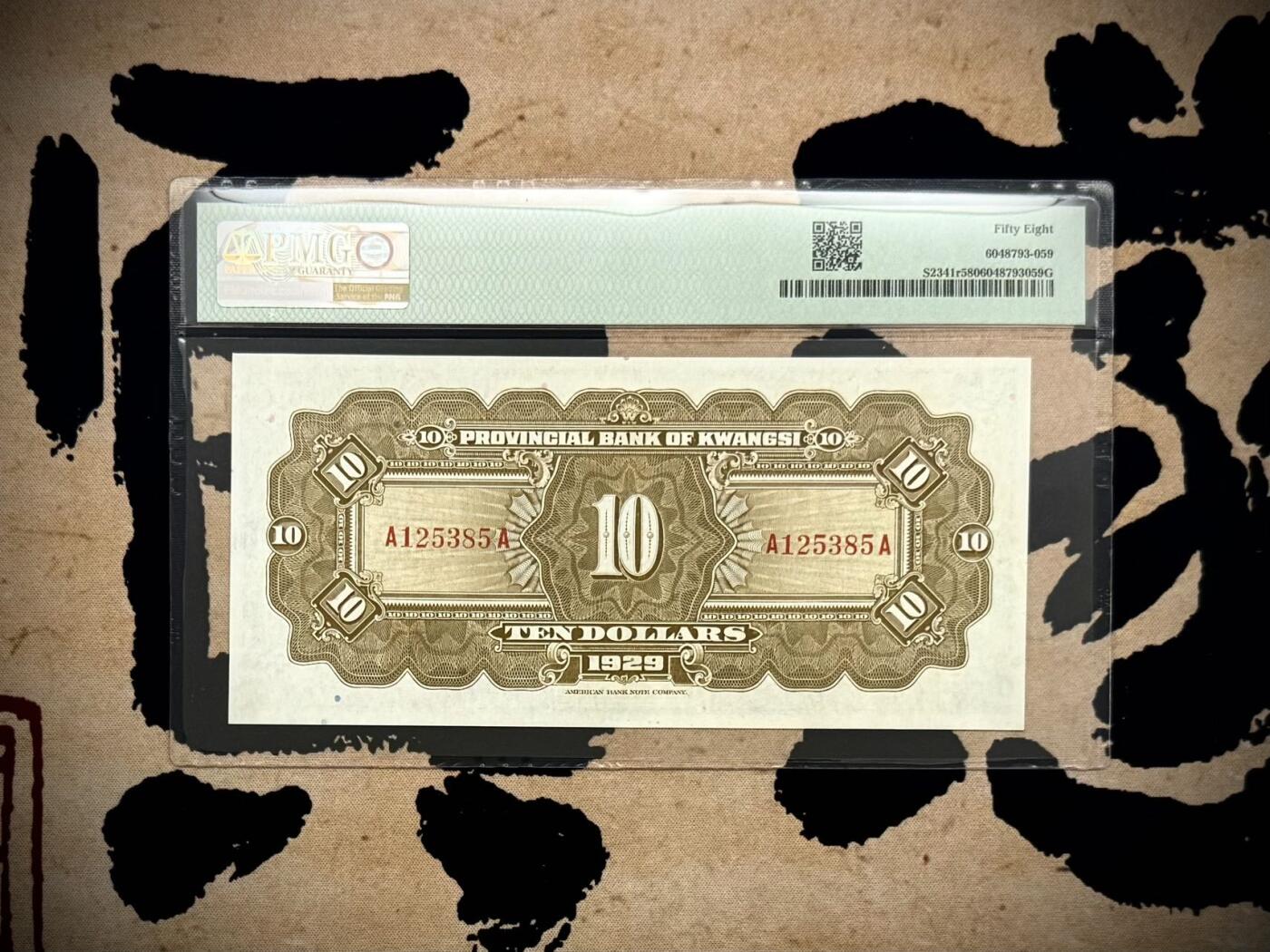 【乾奕收藏】出民国18年1929年广西省银行美钞版拾圆一枚，桂林伏波山图案，号码全程无47，美国PMG58分，民国纸币经过80年能保存如此品相实属难得，喜欢的老板不要错过，评级币一切以分数为准，售出非假不退