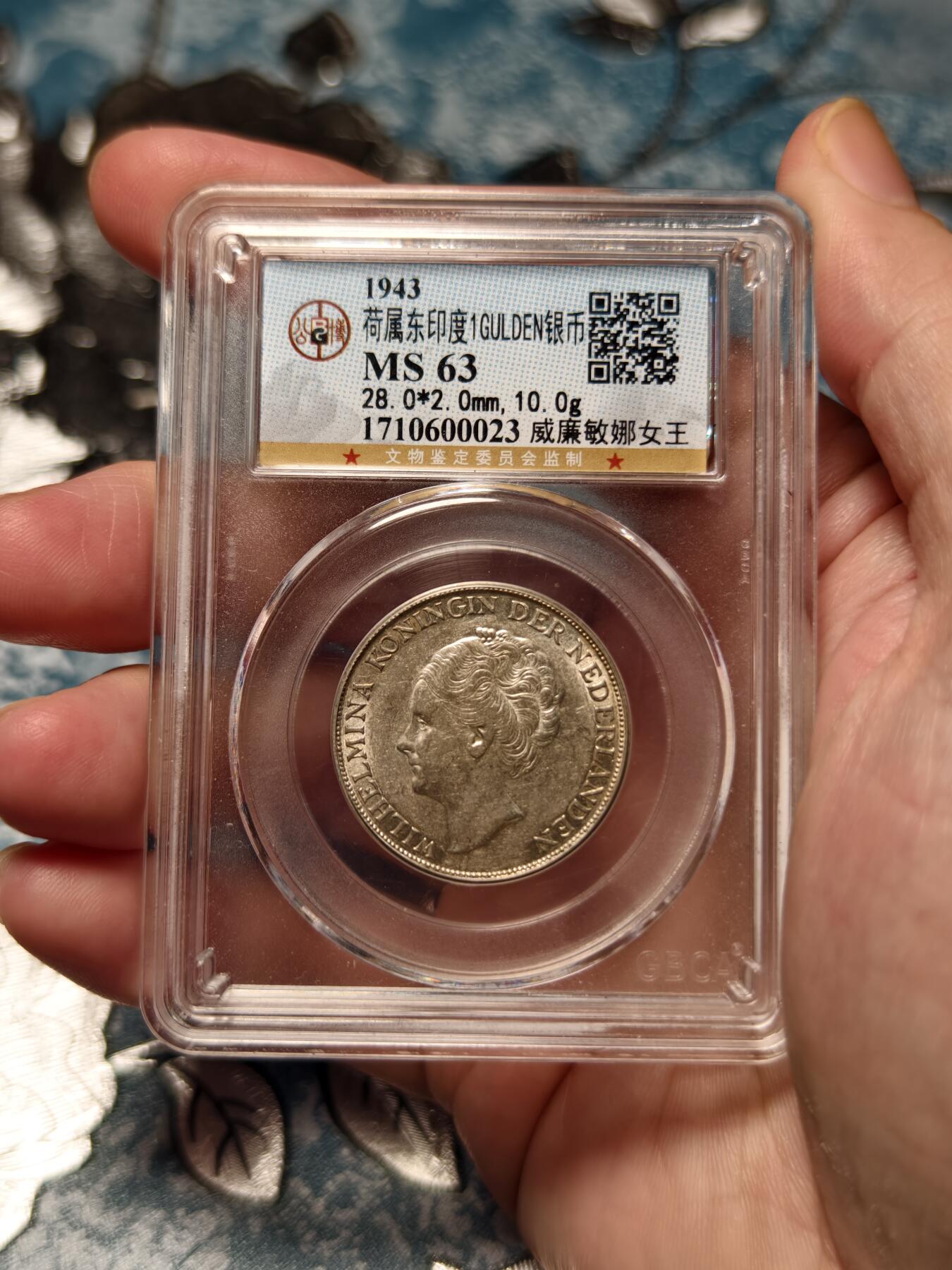 抚柳草堂-第十九期章牌钱币  奖章勋章限时免佣 满百包邮 放漏专场 1943荷属东印度1GULDEN银币 威廉敏娜女王 底板丝滑发丝清晰 公博ms63 二战期间荷兰本土被纳粹占领该币由美国丹佛造币厂铸造 主要供荷属东印度使用 是战时特殊发行的银币 