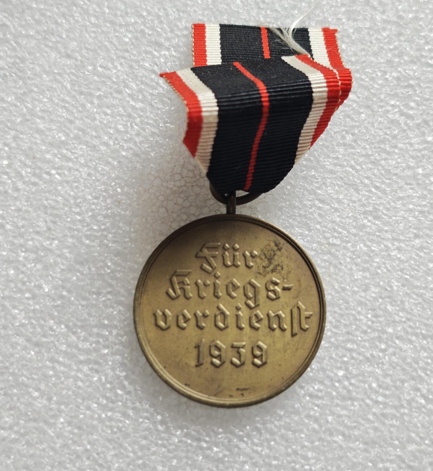 瓶子🏺第234期拍卖会  德国1939年战功奖章（Kriegsverdienstmedaille 1939），也被称为“圆盘战功章”或“无剑战功奖章”  正面中央为马耳他十字造型，十字中心是万字徽记，十字臂面为颗粒状纹理 ​ 背面刻有哥特体德文 Für Kriegsverdienst 1939，意为“为了战功，1939年”