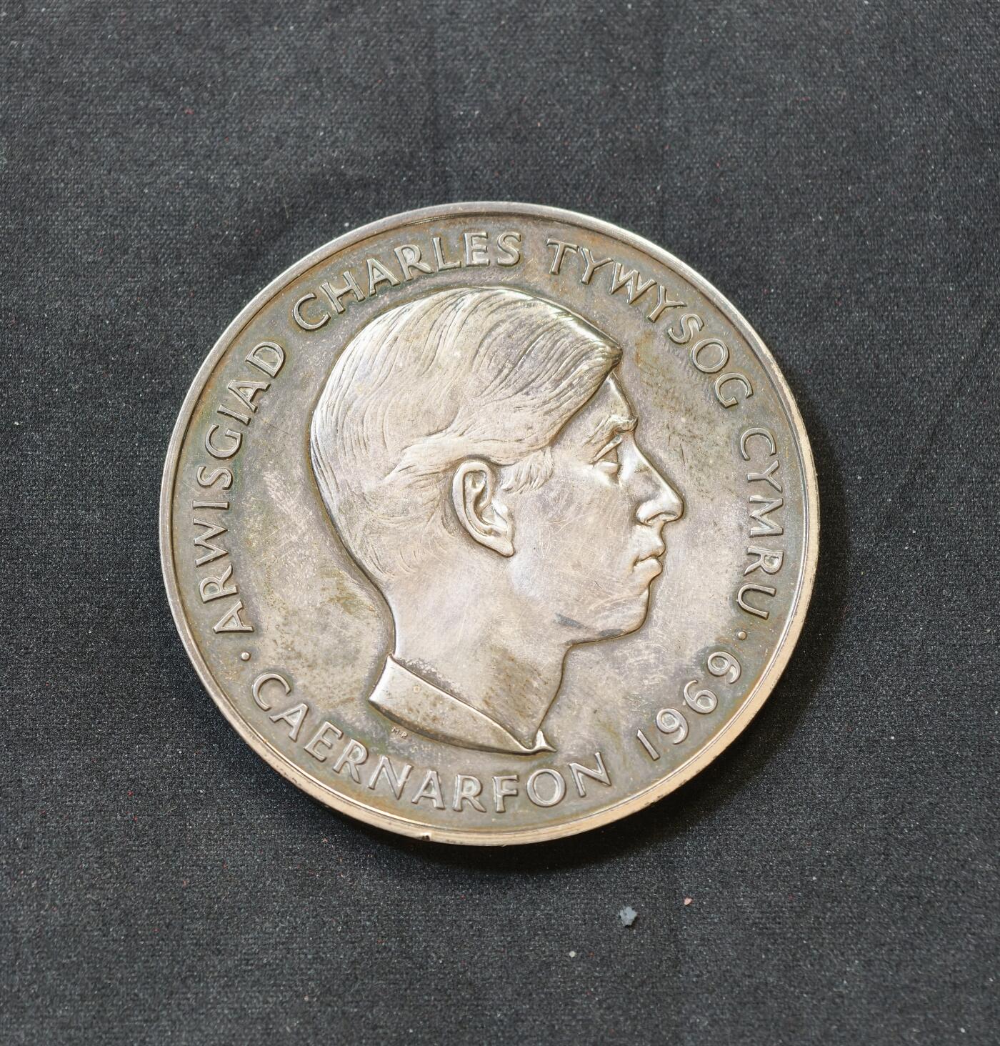 “方寸甄品”甄品场，甄臻铺-世界币章拍卖（第57期，直播拍卖），送拍享返佣金等优惠多多 1969年英国威尔士亲王加冕银质纪念章，直径57毫米，重97.172克，925银标记，带原装盒。正面是威尔士亲王查尔斯头像，背面是威尔士龙