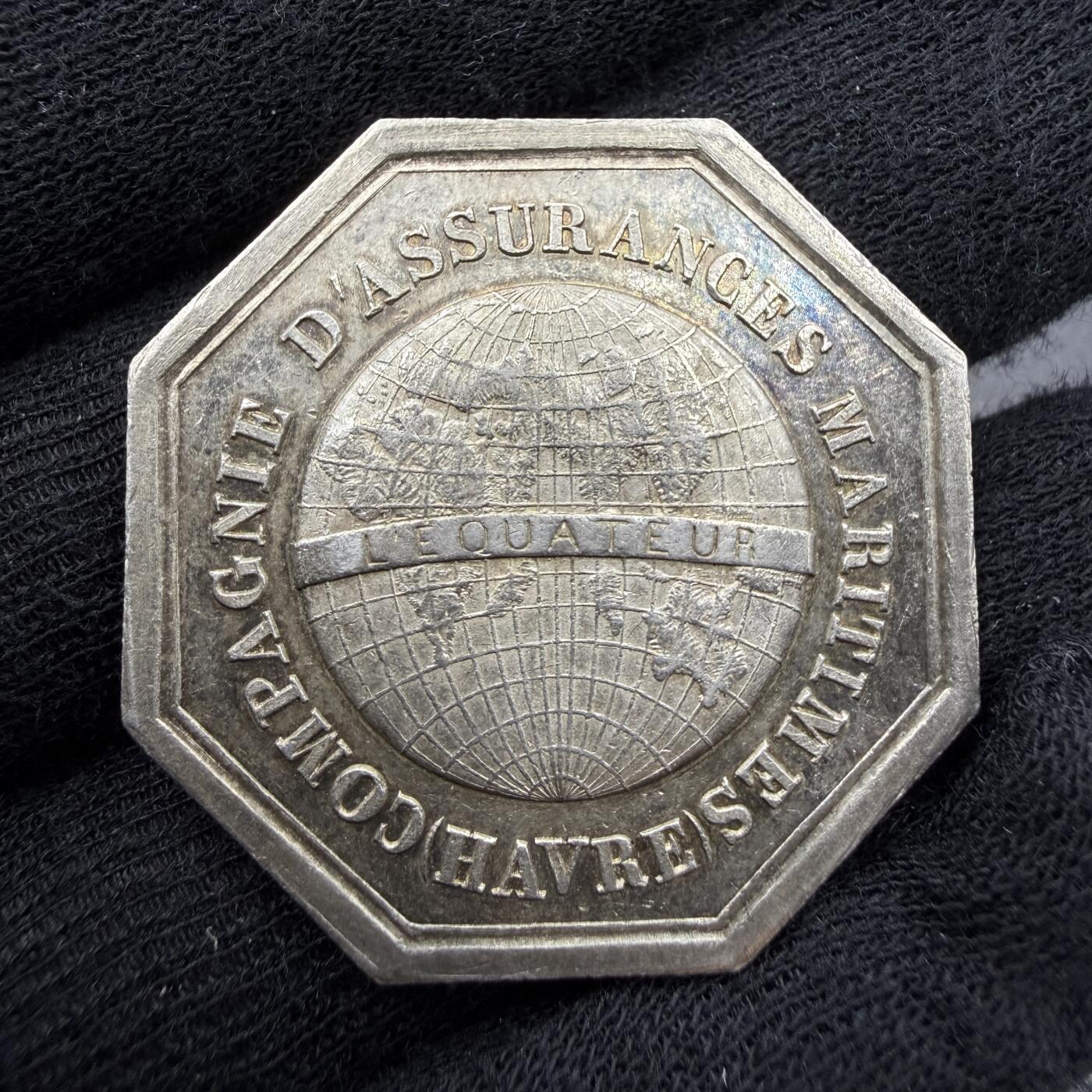 「木头集藏」“春启藏心”——章牌精品专场 CAQUE F.～法国勒阿弗尔海上保险公司八角银章，直径：35.5 mm，19.1 g，边铭：丰饶角 ARGENT，正面刻画勒阿弗尔市火蝾螈城市盾徽，背面是刻有经纬线的地球，标注L'ÉQUATEUR（赤道），象征公司的全球航运保险业务，法语：“勒阿弗尔海上保险公司”。刻画细致，比较少见。