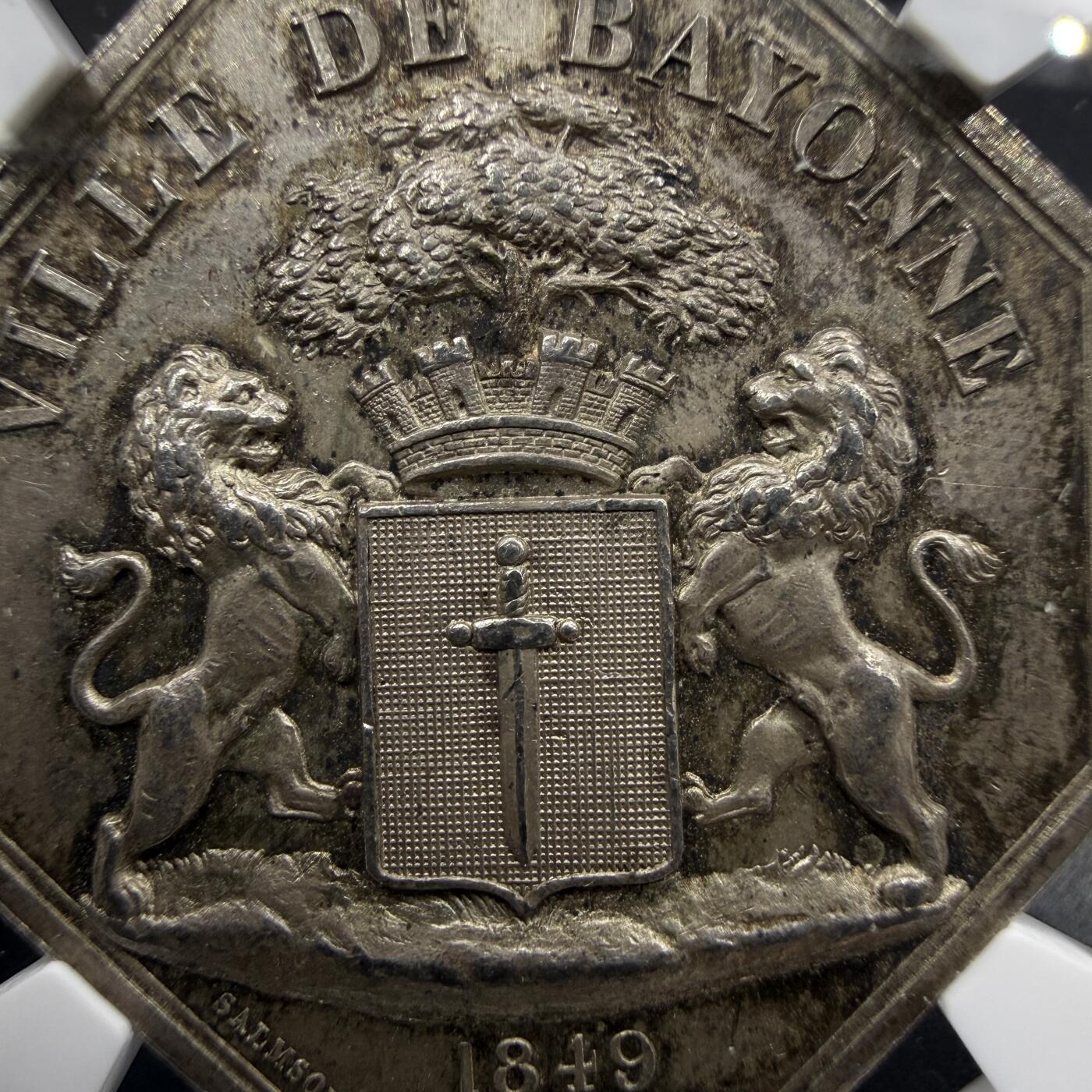 「木头集藏」“春启藏心”——章牌精品专场 1849年法国巴约讷煤气照明公司八角银章，MS 62 ，直径：32 mm，正面女神手持火炬，背景是煤气厂的工业设施管道、烟囱，象征煤气照明为城市带来光明与文明。背面刻画巴约讷市城市盾徽，上方刻画城冠与橡树，代表守护与力量，非常少见的八角，品相不错。