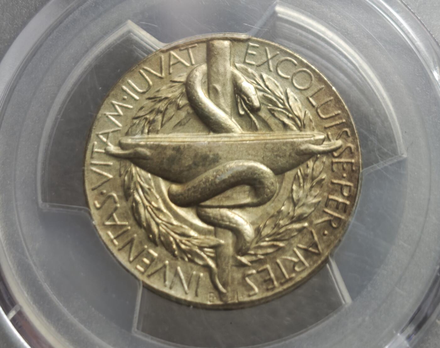 瓶子🏺第234期拍卖会  瑞典诺贝尔医学奖提名委员会镀金银质纪念章（1984年）   这是一枚瑞典诺贝尔医学奖提名委员会发行的镀金银质纪念章，铸造于1984年，由PCGS评级为SP 62（样币级，未流通）阿斯克勒庇俄斯之杖（Rod of Asclepius），即蛇缠绕在权杖上，是医学的经典象征，下方搭配药碗与月桂叶（象征胜利与荣誉）这枚章是诺贝尔医学奖提名委员会的官方纪念章，用于表彰或馈赠参与诺贝尔医学奖提名的专家学者