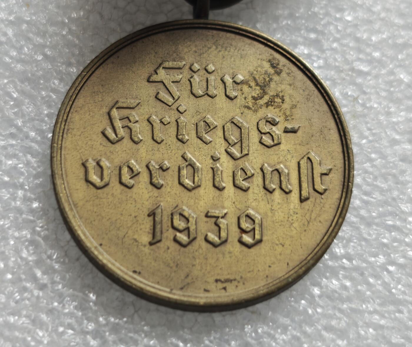 瓶子🏺第234期拍卖会  德国1939年战功奖章（Kriegsverdienstmedaille 1939），也被称为“圆盘战功章”或“无剑战功奖章”  正面中央为马耳他十字造型，十字中心是万字徽记，十字臂面为颗粒状纹理 ​ 背面刻有哥特体德文 Für Kriegsverdienst 1939，意为“为了战功，1939年”