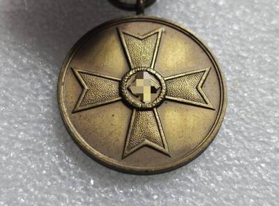 瓶子🏺第234期拍卖会 -  德国1939年战功奖章（Kriegsverdienstmedaille 1939），也被称为“圆盘战功章”或“无剑战功奖章”  正面中央为马耳他十字造型，十字中心是万字徽记，十字臂面为颗粒状纹理 ​ 背面刻有哥特体德文 Für Kriegsverdienst 1939，意为“为了战功，1939年”