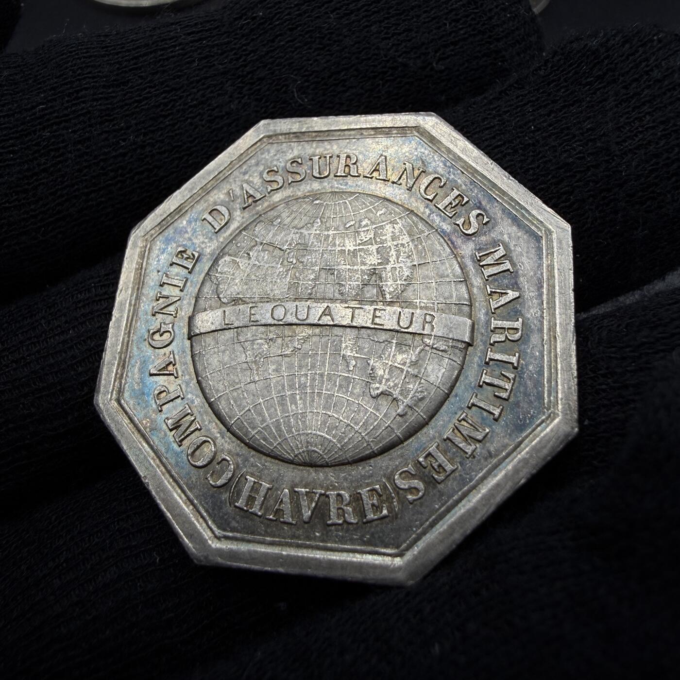 「木头集藏」“春启藏心”——章牌精品专场 CAQUE F.～法国勒阿弗尔海上保险公司八角银章，直径：35.5 mm，19.1 g，边铭：丰饶角 ARGENT，正面刻画勒阿弗尔市火蝾螈城市盾徽，背面是刻有经纬线的地球，标注L'ÉQUATEUR（赤道），象征公司的全球航运保险业务，法语：“勒阿弗尔海上保险公司”。刻画细致，比较少见。