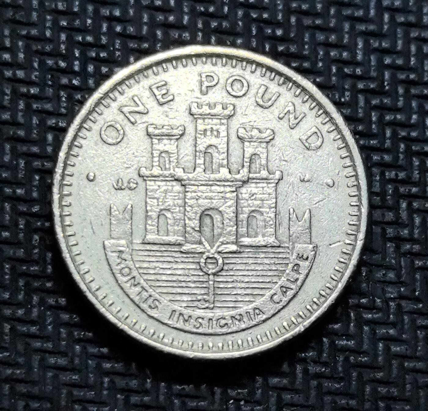 外国优质老铜币银币苏联纪念章，每周六晚九点倒数截拍，满百包邮可寄存，持续收拍 直布罗陀城堡徽章主题 1 英镑硬币，正面为伊丽莎白二世头像，背面镌刻直布罗陀标志性城堡纹章与拉丁语格言 “MONTIS INSIGNIA CALPE”（卡尔佩山的标志），是英属海外领地身份象征的经典载体。镍黄铜材质，纹饰规整，兼具收藏与地域文化叙事价值。