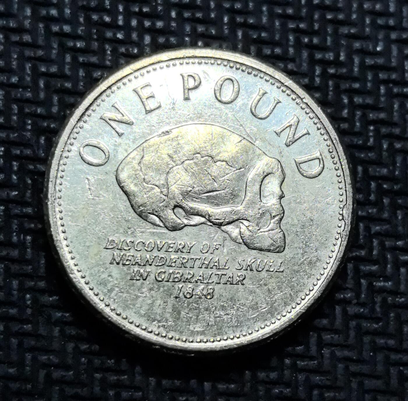 外国优质老铜币银币苏联纪念章，每周六晚九点倒数截拍，满百包邮可寄存，持续收拍 直布罗陀尼安德特人头骨发现纪念 1 英镑硬币，正面为伊丽莎白二世头像，背面镌刻 1848 年直布罗陀发现的尼安德特人头骨化石，将古人类考古史与钱币艺术结合。镍黄铜材质，图案细节清晰，是兼具科学叙事与收藏价值的英属海外领地特色纪念币。