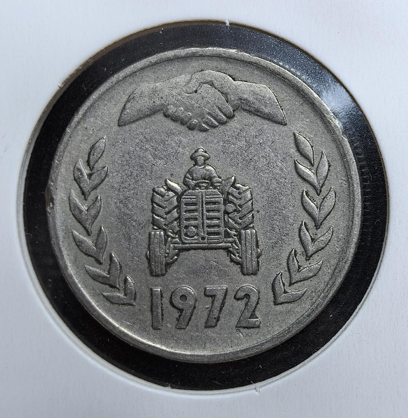 外国优质老铜币银币苏联纪念章，每周六晚九点倒数截拍，满百包邮可寄存，持续收拍 阿尔及利亚1972 年 1 第纳尔，正面握手与拖拉机图案象征合作与农业发展，背面阿拉伯文与数字纹饰充满北非伊斯兰风情，包浆自然，是小众非洲钱币收藏的趣味之选。