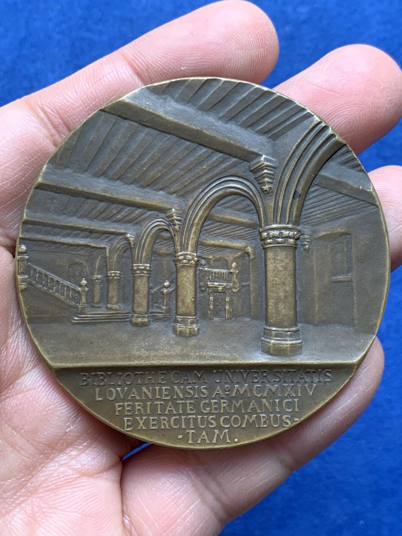 《竞宝斋》第475场 周日，周一 2场连拍 （全场包邮）欢迎送拍 1921年美国铸造比利时鲁汶大学图书馆纪念章，该纪念章英国帝国战争博物馆有藏，极具历史背景和意义，值得收藏品鉴，少见品。正面文字：（拉丁语，意为“美国于1921年恢复人道精神”）。图案：美国白头鹰立于盾徽之上，盾徽内是圣母与圣子像，两侧分别嵌有美国国旗纹章和比利时雄狮纹章，象征美比两国的联结。背面：（拉丁语，意为“1914年被德国军队焚毁的鲁汶大学图书馆”）。图案：刻画鲁汶大学图书馆内部的罗马式拱