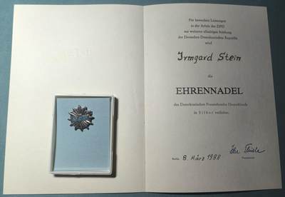 盛世勋华——号角文化勋章邮票专场拍卖第311期 - 东德德意志妇女联盟（DFD）会员伊尔姆加德·斯特恩所获荣誉 DFD银级服务贡献证章 带1988年实发证书