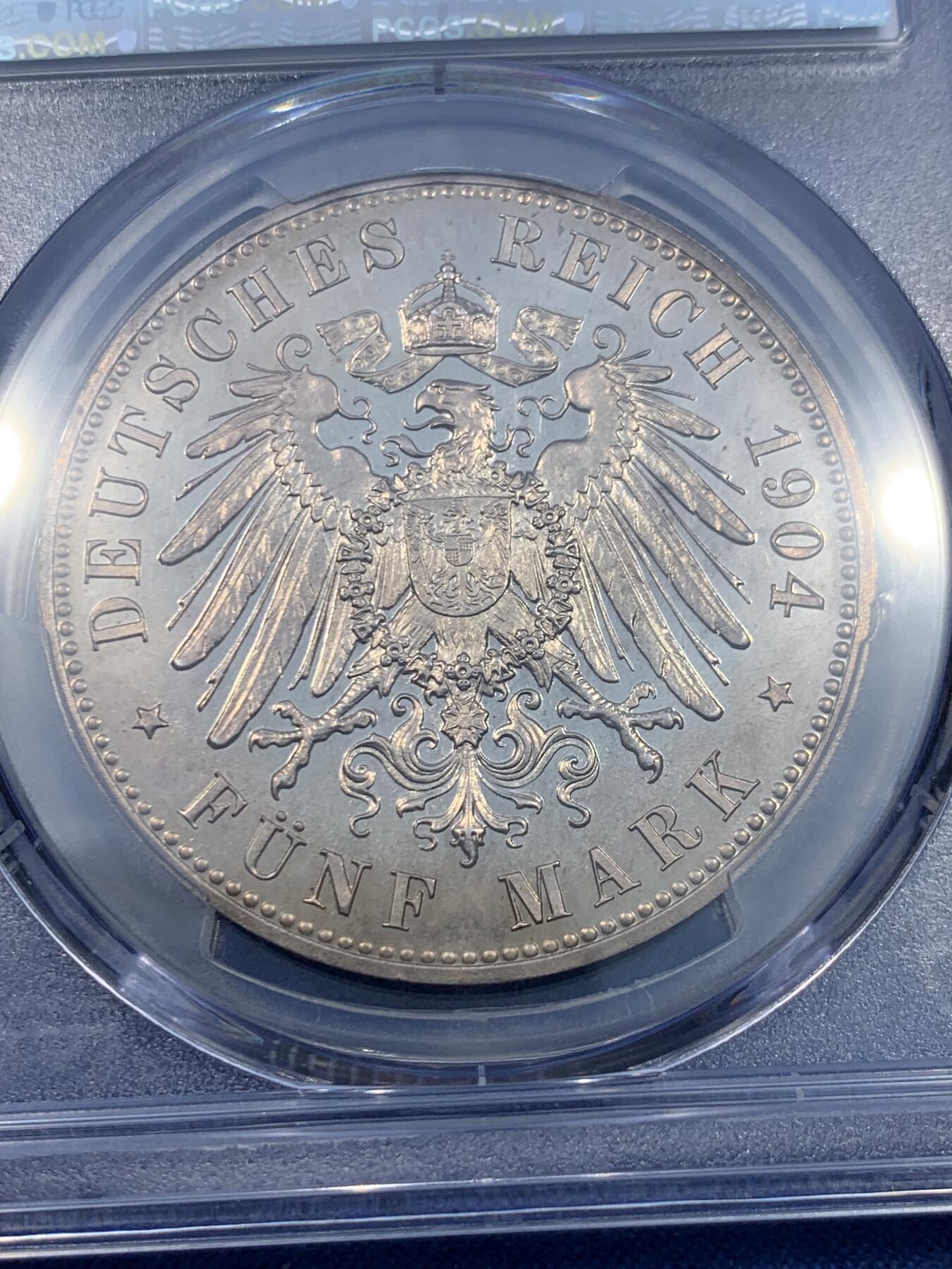 《竞宝斋》第475场 周日，周一 2场连拍 （全场包邮）欢迎送拍 PCGS PR64 德国1904年 梅克伦堡 什未林皇家大婚精制版纪念5马克，用以纪念弗里德里希·弗朗茨四世与汉诺威及坎伯兰的亚历山德拉公主的婚礼，发行量仅2500枚。币面呈现出耀眼的香槟色包浆，如水彩般铺展于表面，强烈的闪光照亮了镜面底板。无论在视觉效果上还是在技术品质上都堪称无可比拟，是极其令人向往的收藏佳品。