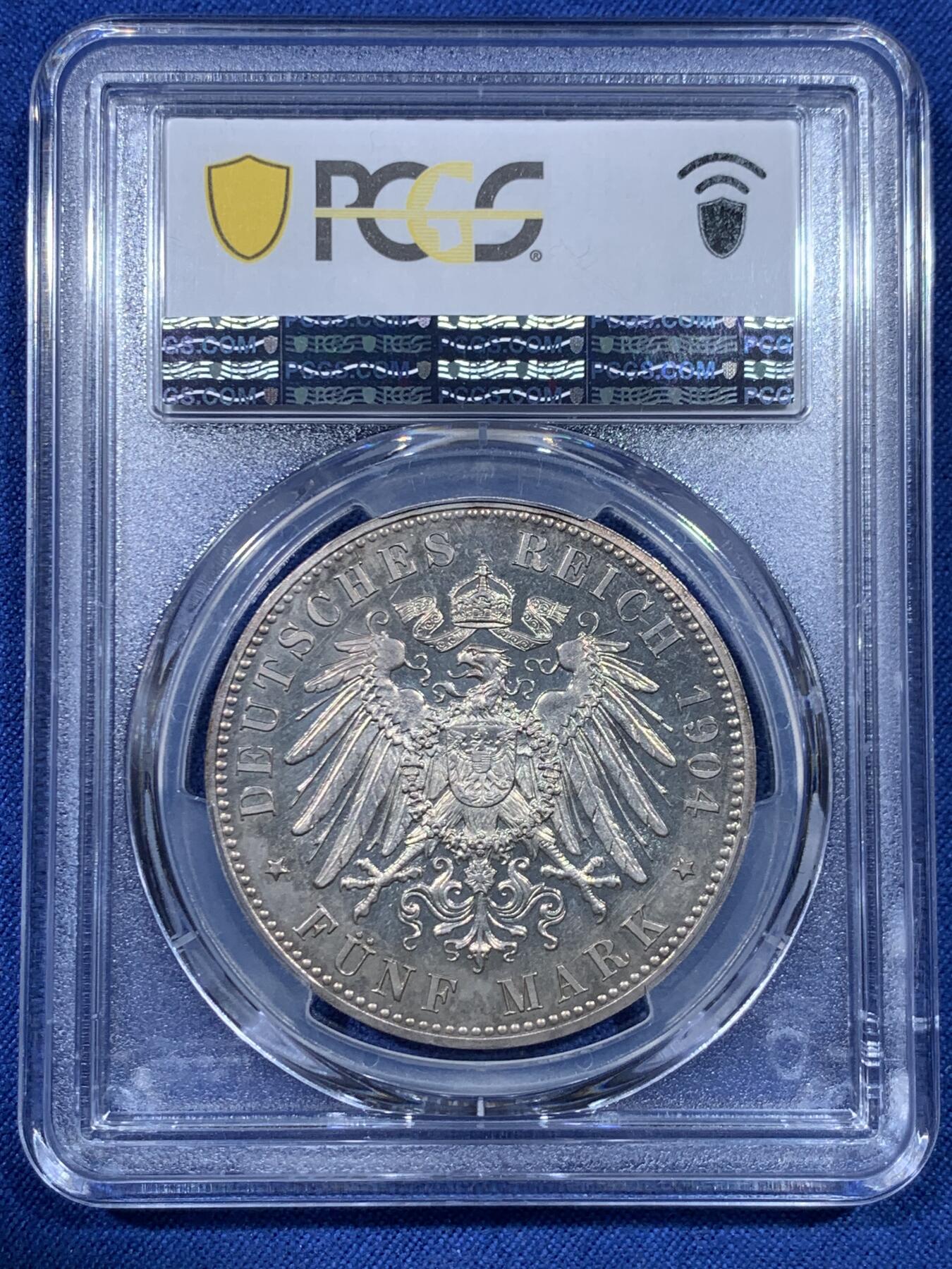 《竞宝斋》第475场 周日，周一 2场连拍 （全场包邮）欢迎送拍 PCGS PR64 德国1904年 梅克伦堡 什未林皇家大婚精制版纪念5马克，用以纪念弗里德里希·弗朗茨四世与汉诺威及坎伯兰的亚历山德拉公主的婚礼，发行量仅2500枚。币面呈现出耀眼的香槟色包浆，如水彩般铺展于表面，强烈的闪光照亮了镜面底板。无论在视觉效果上还是在技术品质上都堪称无可比拟，是极其令人向往的收藏佳品。