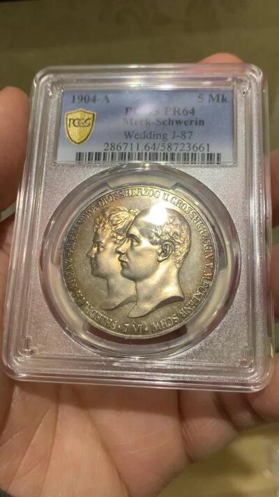 《竞宝斋》第475场 周日，周一 2场连拍 （全场包邮）欢迎送拍 PCGS PR64 德国1904年 梅克伦堡 什未林皇家大婚精制版纪念5马克，用以纪念弗里德里希·弗朗茨四世与汉诺威及坎伯兰的亚历山德拉公主的婚礼，发行量仅2500枚。币面呈现出耀眼的香槟色包浆，如水彩般铺展于表面，强烈的闪光照亮了镜面底板。无论在视觉效果上还是在技术品质上都堪称无可比拟，是极其令人向往的收藏佳品。