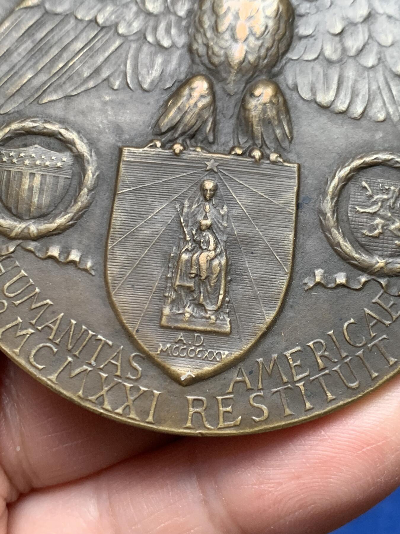 《竞宝斋》第475场 周日，周一 2场连拍 （全场包邮）欢迎送拍 1921年美国铸造比利时鲁汶大学图书馆纪念章，该纪念章英国帝国战争博物馆有藏，极具历史背景和意义，值得收藏品鉴，少见品。正面文字：（拉丁语，意为“美国于1921年恢复人道精神”）。图案：美国白头鹰立于盾徽之上，盾徽内是圣母与圣子像，两侧分别嵌有美国国旗纹章和比利时雄狮纹章，象征美比两国的联结。背面：（拉丁语，意为“1914年被德国军队焚毁的鲁汶大学图书馆”）。图案：刻画鲁汶大学图书馆内部的罗马式拱