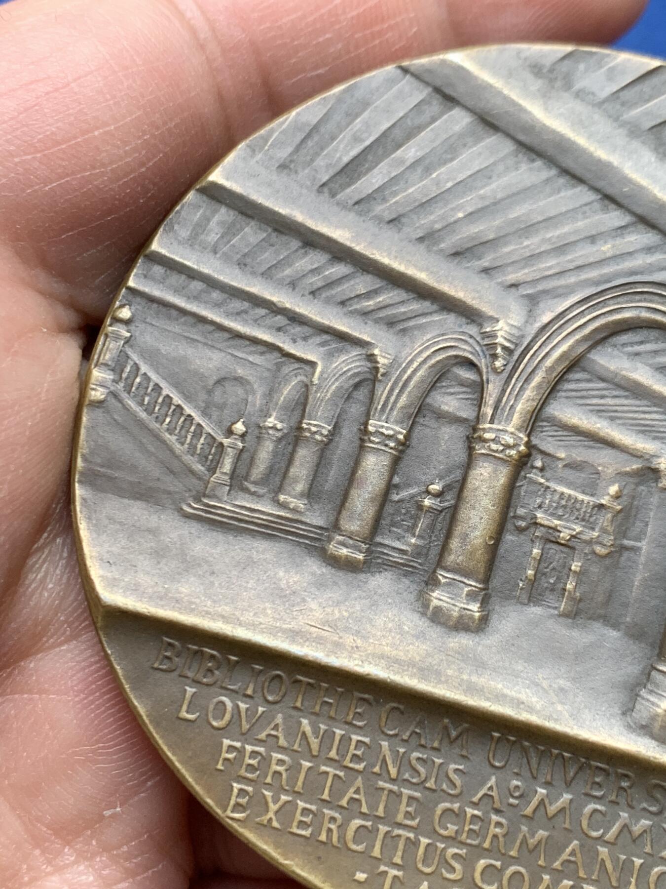 《竞宝斋》第475场 周日，周一 2场连拍 （全场包邮）欢迎送拍 1921年美国铸造比利时鲁汶大学图书馆纪念章，该纪念章英国帝国战争博物馆有藏，极具历史背景和意义，值得收藏品鉴，少见品。正面文字：（拉丁语，意为“美国于1921年恢复人道精神”）。图案：美国白头鹰立于盾徽之上，盾徽内是圣母与圣子像，两侧分别嵌有美国国旗纹章和比利时雄狮纹章，象征美比两国的联结。背面：（拉丁语，意为“1914年被德国军队焚毁的鲁汶大学图书馆”）。图案：刻画鲁汶大学图书馆内部的罗马式拱