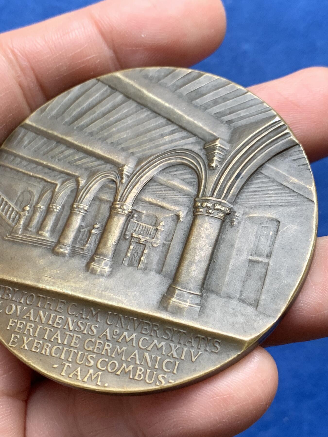 《竞宝斋》第475场 周日，周一 2场连拍 （全场包邮）欢迎送拍 1921年美国铸造比利时鲁汶大学图书馆纪念章，该纪念章英国帝国战争博物馆有藏，极具历史背景和意义，值得收藏品鉴，少见品。正面文字：（拉丁语，意为“美国于1921年恢复人道精神”）。图案：美国白头鹰立于盾徽之上，盾徽内是圣母与圣子像，两侧分别嵌有美国国旗纹章和比利时雄狮纹章，象征美比两国的联结。背面：（拉丁语，意为“1914年被德国军队焚毁的鲁汶大学图书馆”）。图案：刻画鲁汶大学图书馆内部的罗马式拱