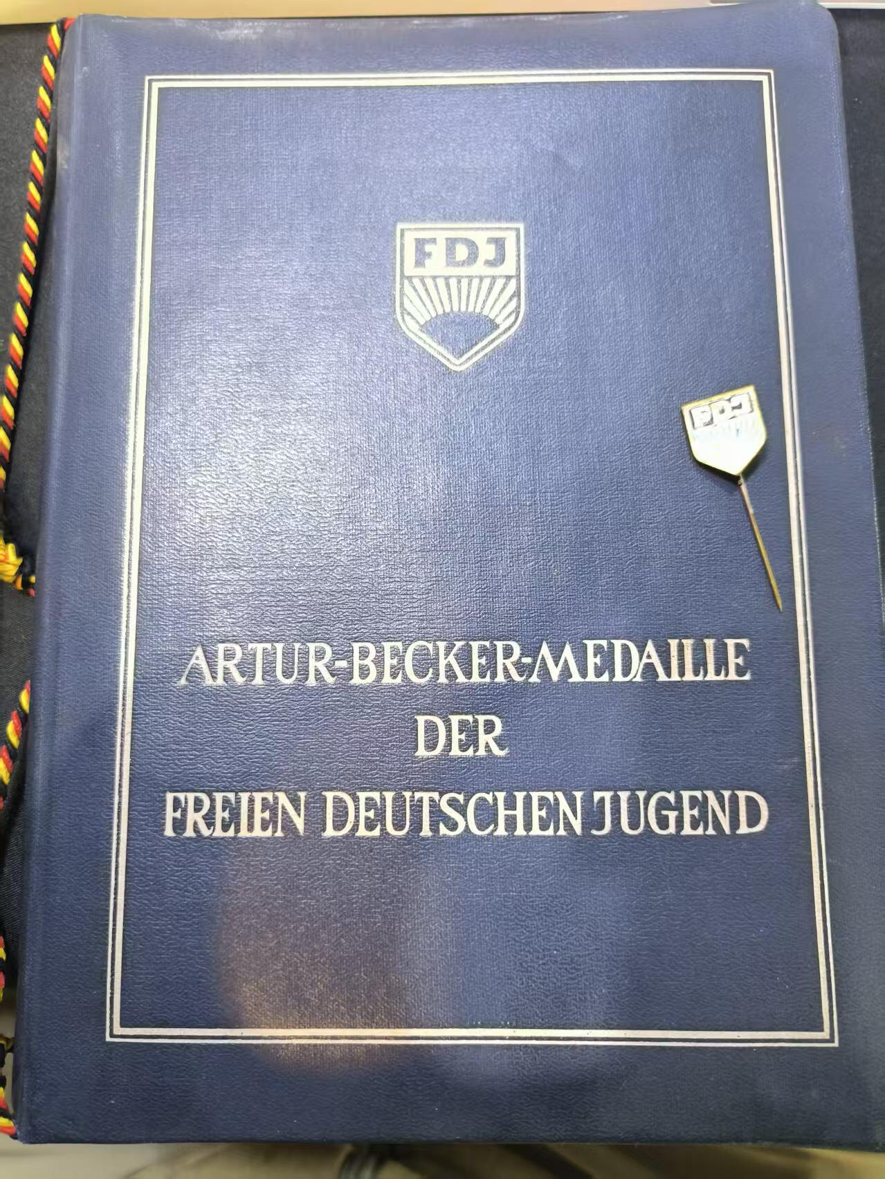 云宸嘉赏-勋臻文献佳藏优品精选场次（低佣 转发佣金红包） 民主德国自由德国青年团-兹表其奥古斯特・贝贝尔青年突击旅在德青少年的社会主义教育工作  属于稀有的青年团集体荣誉证书 早期版本厚壳  带青年团珐琅证章一套 