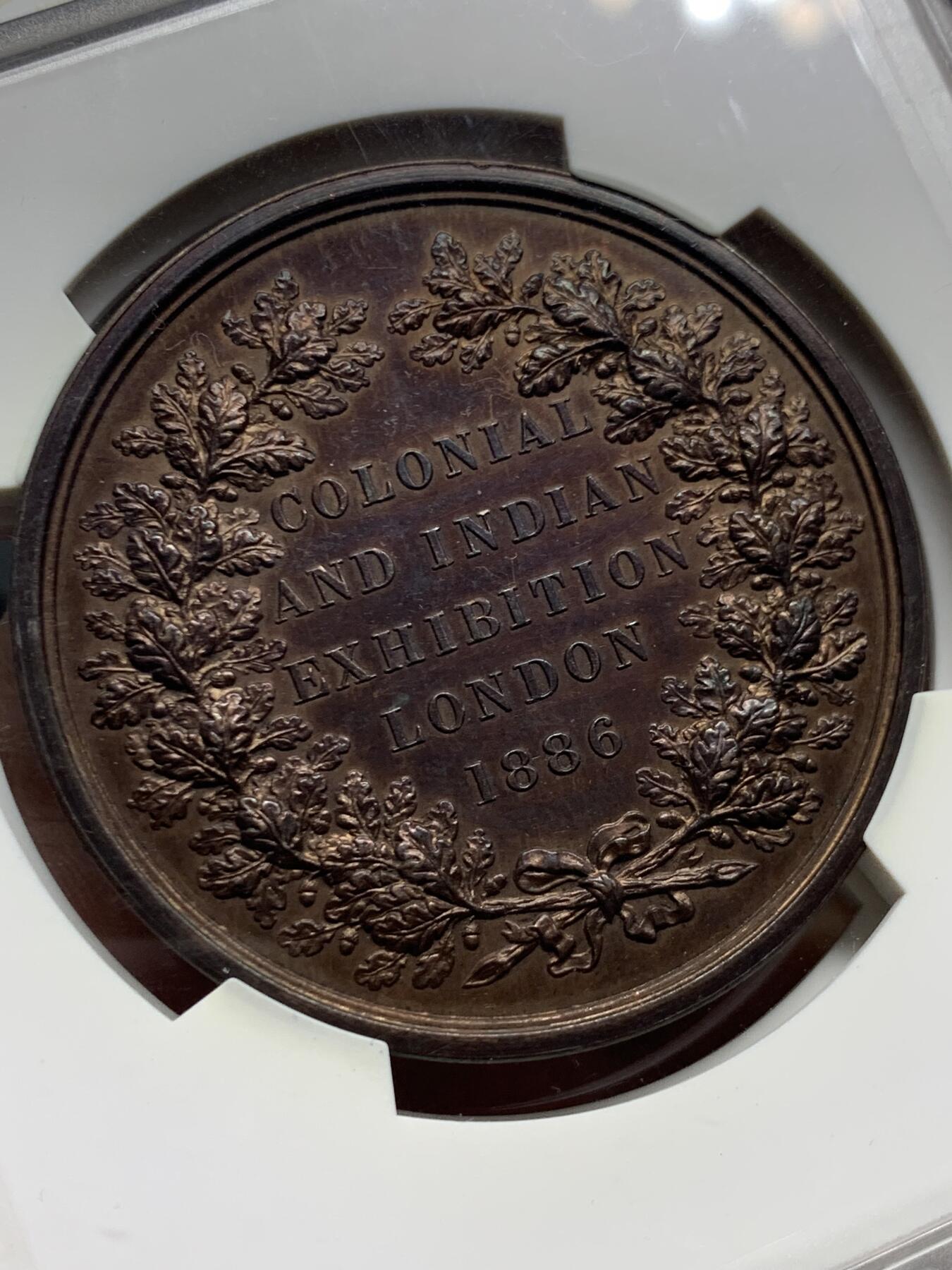 《竞宝斋》第476场 周日，周一 2场连拍 （全场包邮）欢迎送拍 1886年英国印度殖民地伦敦博览会纪念章，正面：此时尚未成为英国国王的威尔士亲王爱德华，背面：铭文纪念。皇家造币厂首席雕刻师L.C怀恩作品，直径约52毫米，重约79克。少见品种！加大加厚盒