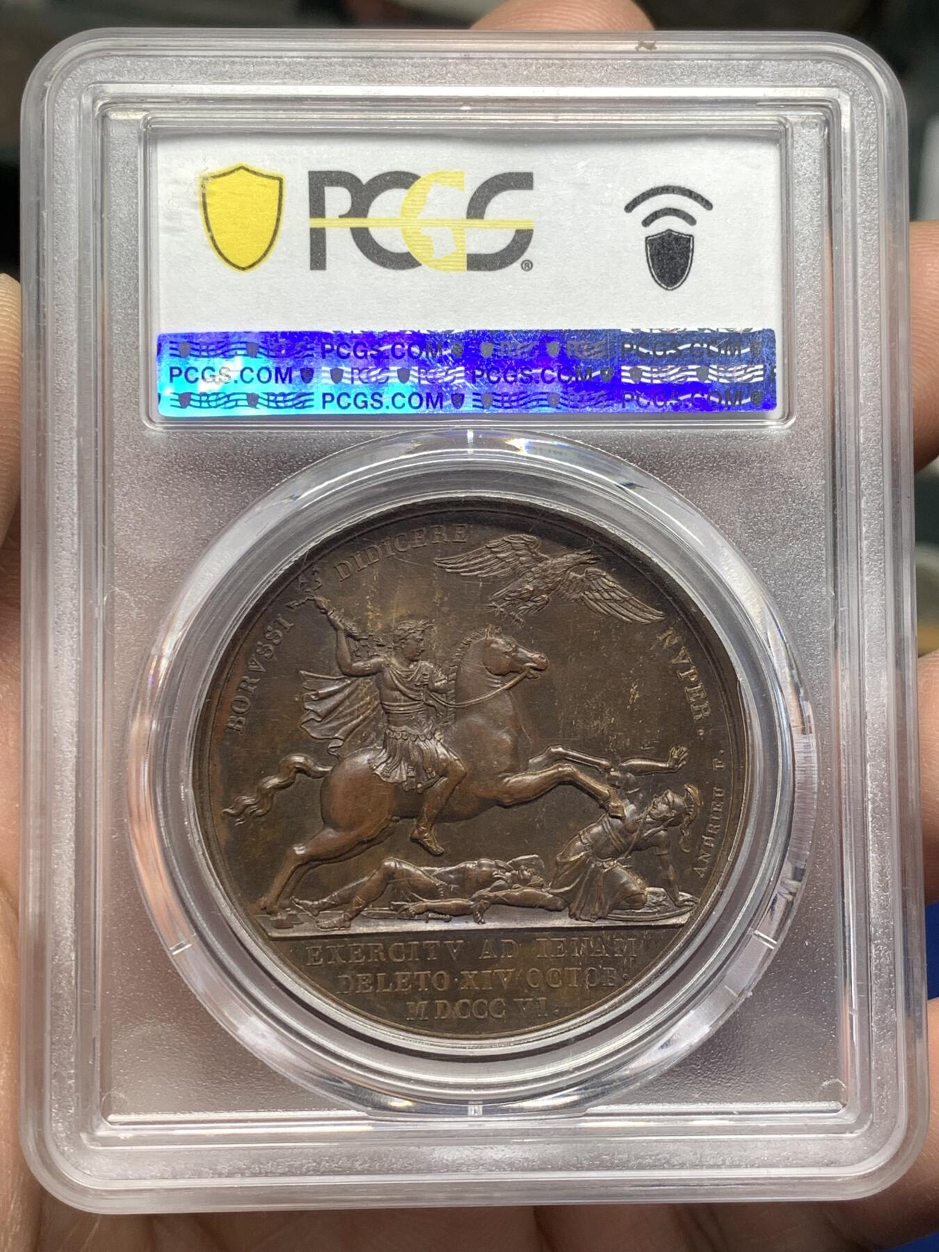 《竞宝斋》第476场 周日，周一 2场连拍 （全场包邮）欢迎送拍 PCGS SP64  法国1806年拿破仑一世耶拿之战原铸铜章 巴黎造币厂巧克力包浆 拿破仑化身朱庇特(罗马神话中众神之王)身披斗篷骑着帝国之鹰腾云凌空 手持闪电权杖 击倒斩杀地上三名巨人 场面英武壮阔设计大胆天马行空 肌肉线条精细优美该战役是拿破仑大破普军经典战役 也是拿章中经典中的经典 加厚盒