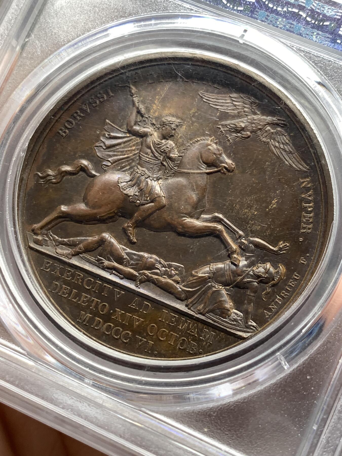 《竞宝斋》第476场 周日，周一 2场连拍 （全场包邮）欢迎送拍 PCGS SP64  法国1806年拿破仑一世耶拿之战原铸铜章 巴黎造币厂巧克力包浆 拿破仑化身朱庇特(罗马神话中众神之王)身披斗篷骑着帝国之鹰腾云凌空 手持闪电权杖 击倒斩杀地上三名巨人 场面英武壮阔设计大胆天马行空 肌肉线条精细优美该战役是拿破仑大破普军经典战役 也是拿章中经典中的经典 加厚盒