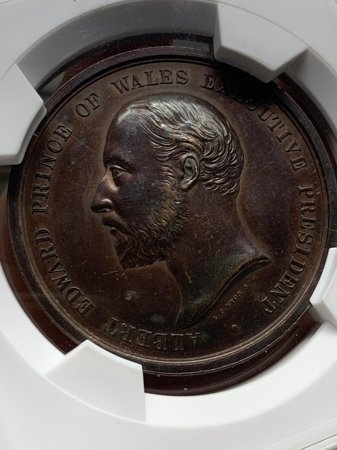 《竞宝斋》第476场 周日，周一 2场连拍 （全场包邮）欢迎送拍 1886年英国印度殖民地伦敦博览会纪念章，正面：此时尚未成为英国国王的威尔士亲王爱德华，背面：铭文纪念。皇家造币厂首席雕刻师L.C怀恩作品，直径约52毫米，重约79克。少见品种！加大加厚盒