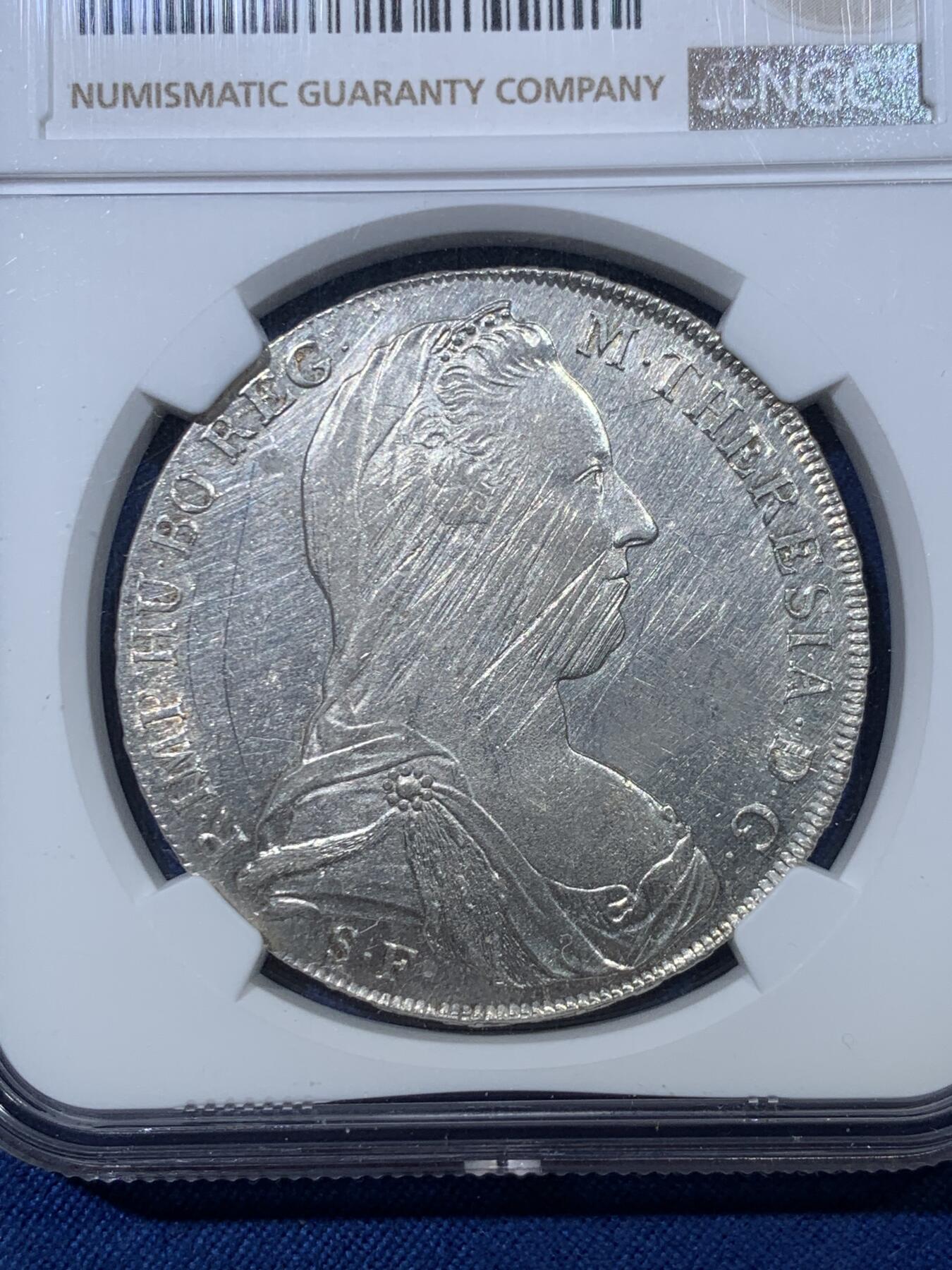 《竞宝斋》第476场 周日，周一 2场连拍 （全场包邮）欢迎送拍 NGC UNCD 1815至1828年意大利米兰版玛丽亚特蕾莎贸易银币经典“中心正圆九珍珠”，应为哈夫纳36a版本，具体自辨。该版本为女皇逝世后，为了迎合近中东贸易货币使用习惯，由奥属意大利米兰造币厂铸造的版本，主要流通于北非、中东地区，是历史上真正参与流通的行用币！NGC严评UNC未流通品，光泽度很好。正面疑似减重痕背面弱打，介意勿拍。