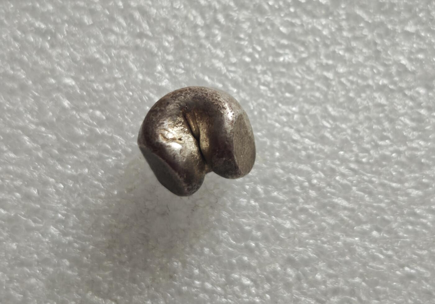 瓶子🏺第235期拍卖会  好品银光1泰铢（15克）  暹罗（泰国）拉玛王朝“屁股银”（Pod Duang / 子弹银）   泰国拉玛王朝（1782–1910年）时期流通的手工打制银锭，在闽南民间被形象称为“尻川银”（屁股银），西方则称其为“子弹银”（Bullet Money） 上方轮形戳记代表法轮，是暹罗王室与佛教法统的象征，寓意佛法永转、王权正统 ​  下方戳记对应拉玛王朝君主的皇家徽记 拉玛四世的“Mongkut”徽