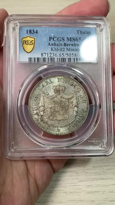 万国钱币拍卖第064期 PCGS MS65 1834年德国安哈尔特-贝恩堡矿业祈祷纹章流通1泰勒 唯一一款贝恩堡窗帘形态1泰勒 小熊爬墙的前身 仅单年发行15000枚且流通充分 即便通货也是难得一见 能达到BU品质可谓凤毛麟角 全深打丝绸转光地板 极美香槟色调淡彩环绕 PCGS唯一冠军分唯一MS 亚军就是XF40 其难度可见一斑 入库收藏重器级别