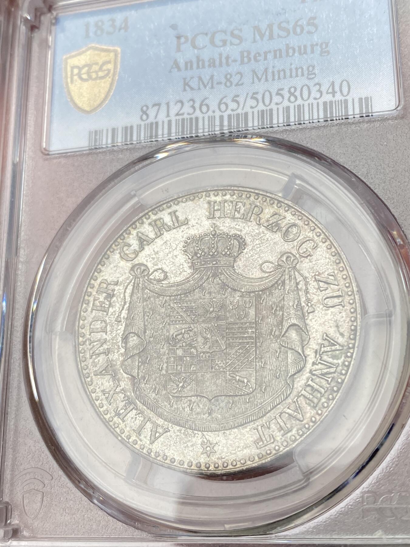 万国钱币拍卖第064期 PCGS MS65 1834年德国安哈尔特-贝恩堡矿业祈祷纹章流通1泰勒 唯一一款贝恩堡窗帘形态1泰勒 小熊爬墙的前身 仅单年发行15000枚且流通充分 即便通货也是难得一见 能达到BU品质可谓凤毛麟角 全深打丝绸转光地板 极美香槟色调淡彩环绕 PCGS唯一冠军分唯一MS 亚军就是XF40 其难度可见一斑 入库收藏重器级别
