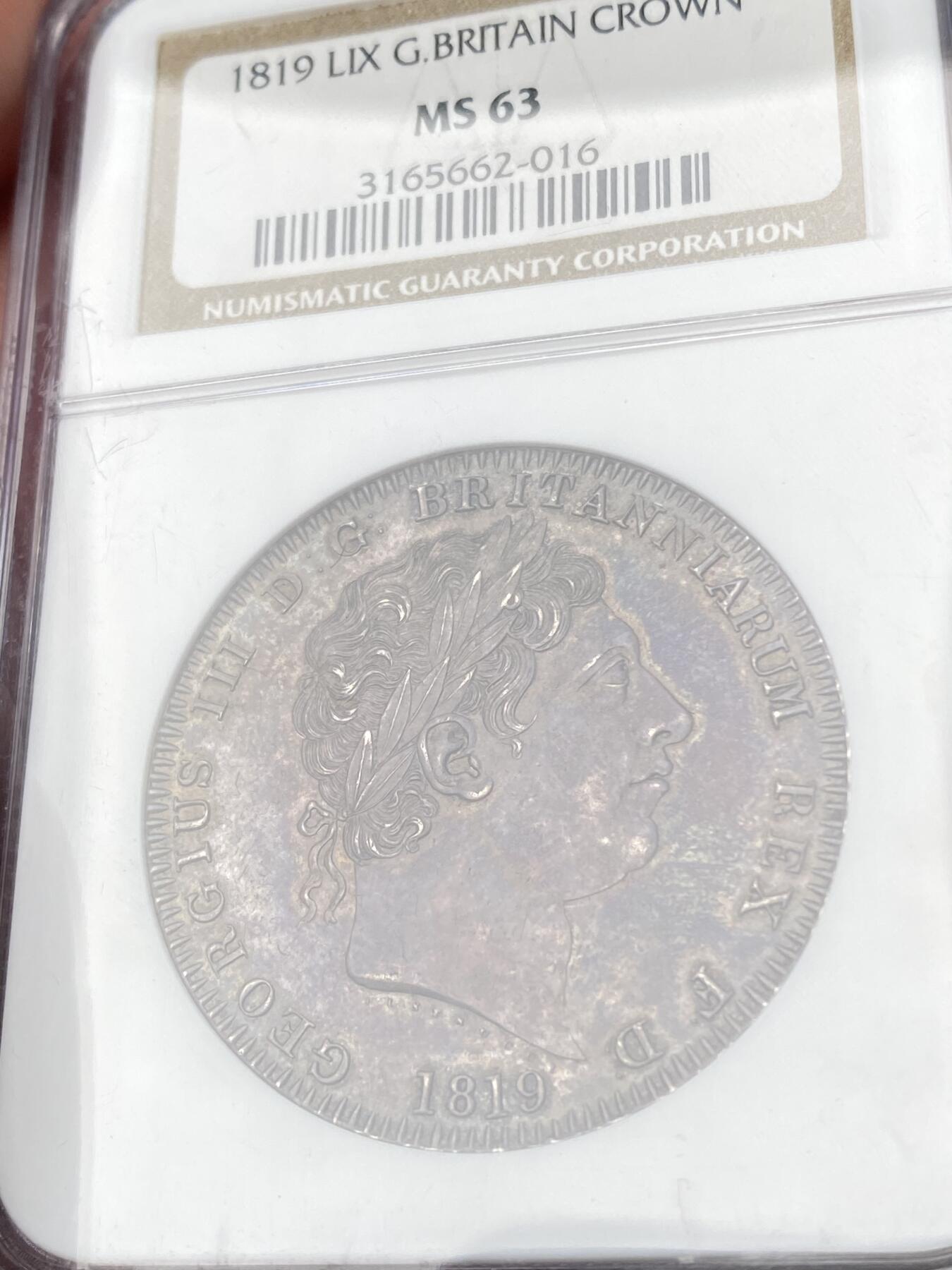 万国钱币拍卖第064期 NGC MS63 1819LIX英国乔治三世马剑克朗 英国马剑系列开山之作 均匀厚重的英式天鹅绒乌云五彩全覆盖 全深打高浮雕轻微类镜面质感 同分中罕见的顶级状态 NGC老盒典藏级品质