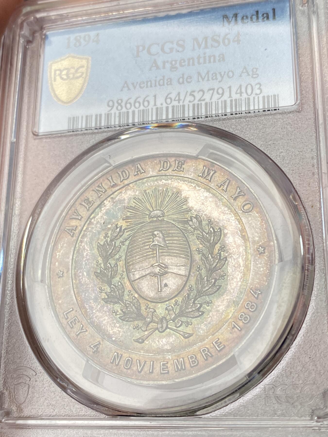 万国钱币拍卖第064期 PCGS MS64 1894年阿根廷布宜诺斯艾利斯五月大道向公众开放纪念大银章 罕见五彩南美银章37MM厚重精铸美丽 其东端玫瑰宫和总统府与西边终点新国会大厦连接起来 道路两旁是法国古典主义建筑和新艺术派建筑 PC唯一冠军分