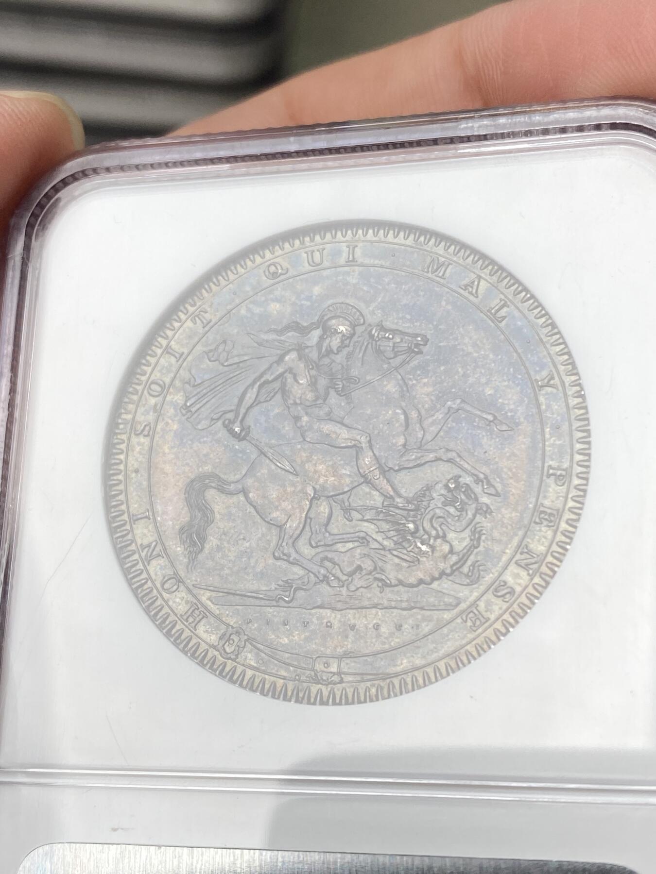 万国钱币拍卖第064期 NGC MS63 1819LIX英国乔治三世马剑克朗 英国马剑系列开山之作 均匀厚重的英式天鹅绒乌云五彩全覆盖 全深打高浮雕轻微类镜面质感 同分中罕见的顶级状态 NGC老盒典藏级品质