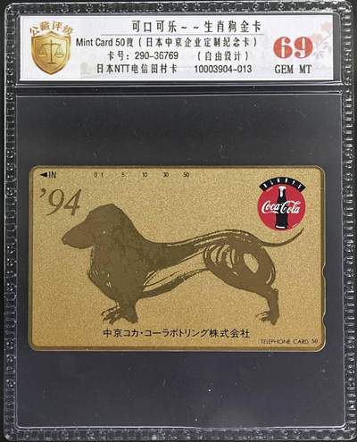 公藏评级第132期评级卡拍卖 - 日本田村卡（可口可乐--生肖狗金卡）一全公藏69分。公藏评级专业有卡号及防伪标。这卡为企业定制卡属自由设计图案。腊肠犬因其体型特征，在日本文化中常被赋予吉祥，招财的寓意。