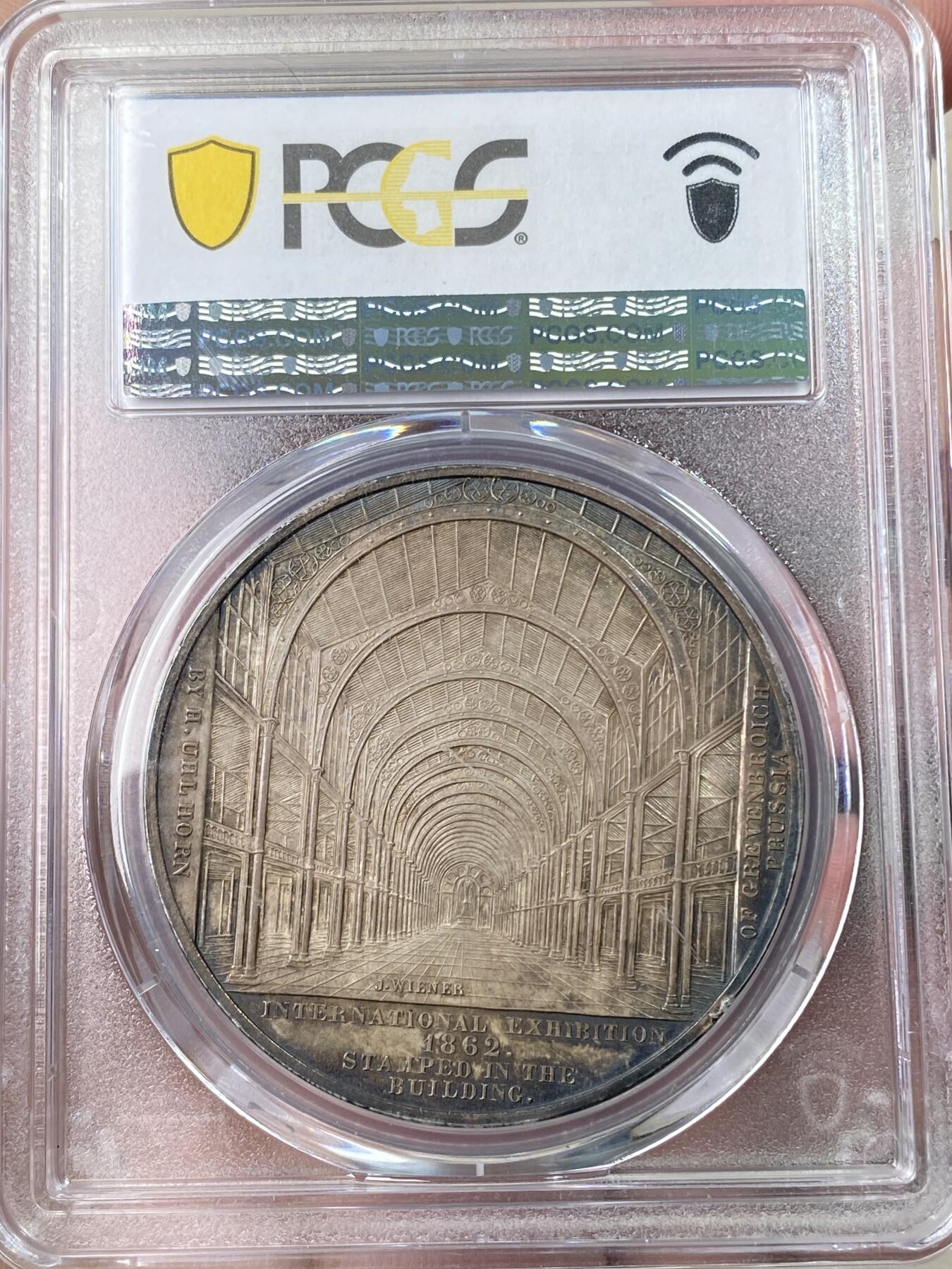 万国钱币拍卖第064期 PCGS MS61 1862年英国伦敦国际工业与艺术博览会纪念银章 同时纪念阿尔伯特亲王 原味深五彩包浆 常见均为镀银 银质罕见 建筑细节丝丝入扣 伦敦大博览会是1862年5月1日至11月1日在英国伦敦南肯辛顿举行的世界博览会 博览会由英国皇家艺术、制造和贸易学会赞助 来自36个国家的28000多家参展商代表了广泛的行业 PC亚军分更高仅一枚